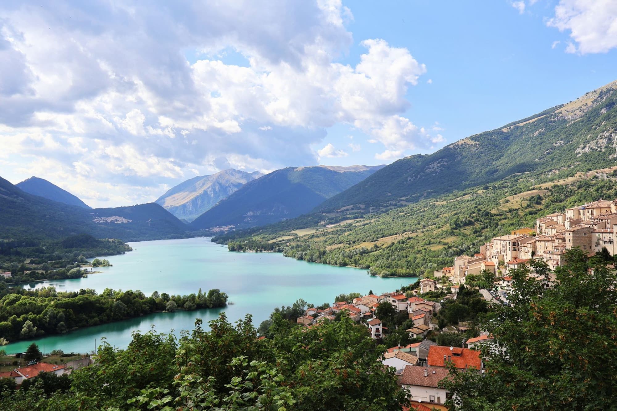 Stunning panoramic view of Villetta Barrea, Abruzzo with lake, mountains, and village.