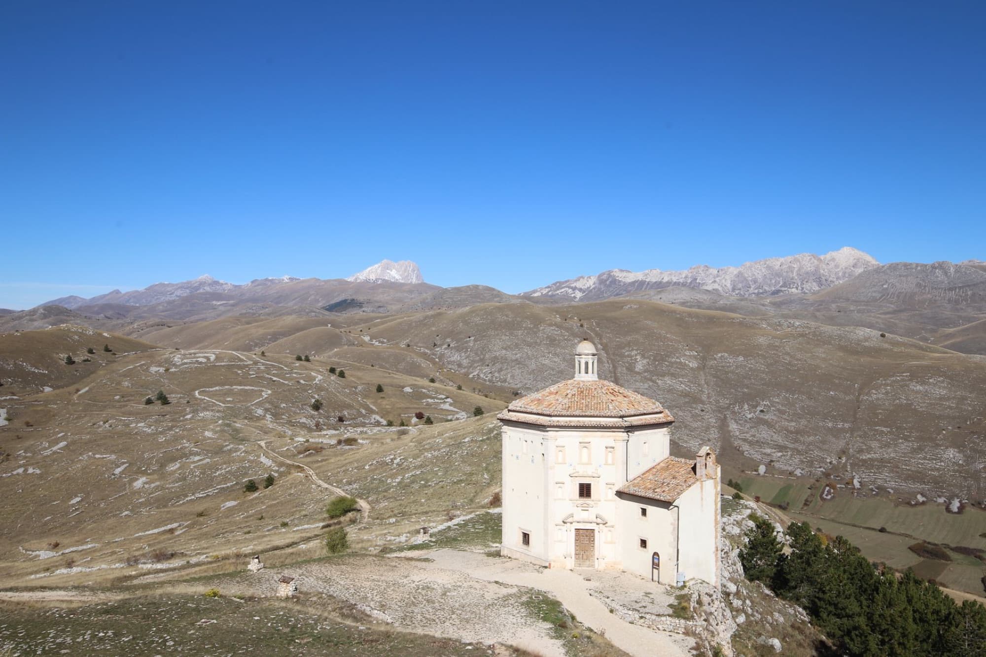 Scenic view of Santa Maria della Pietà church amidst Italy's Abruzzo hills and mountains.