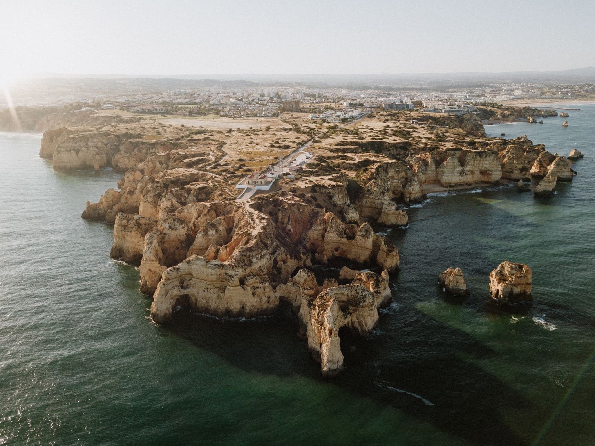 Aerial view of the stunning cliffs and coastline of Algarve, Portugal, with crystal clear sea water.