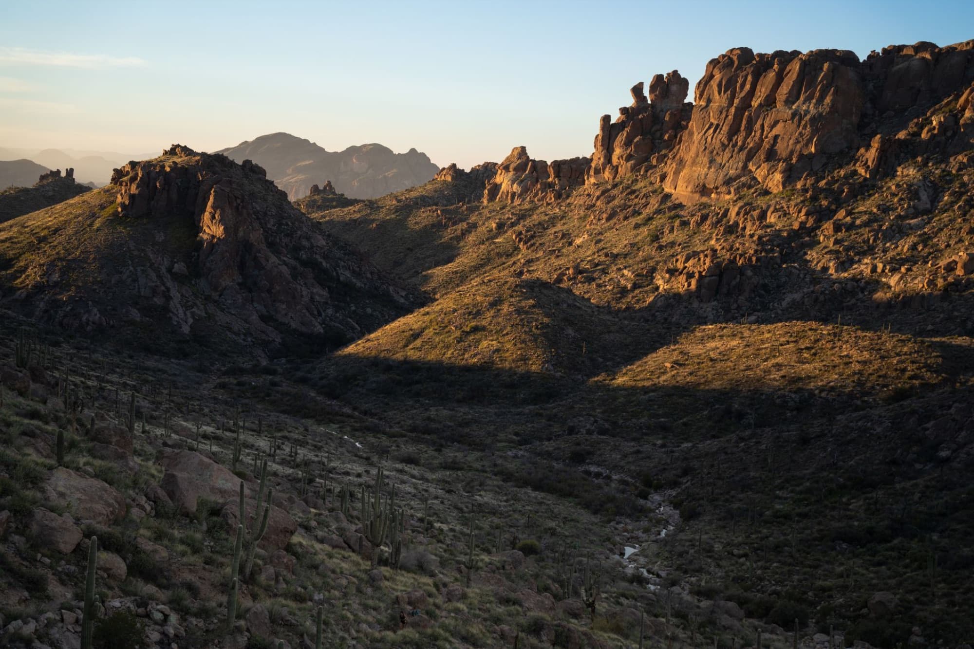 Two stacked rock cairns in a scenic Sedona desert landscape with red rocks and blue sky.