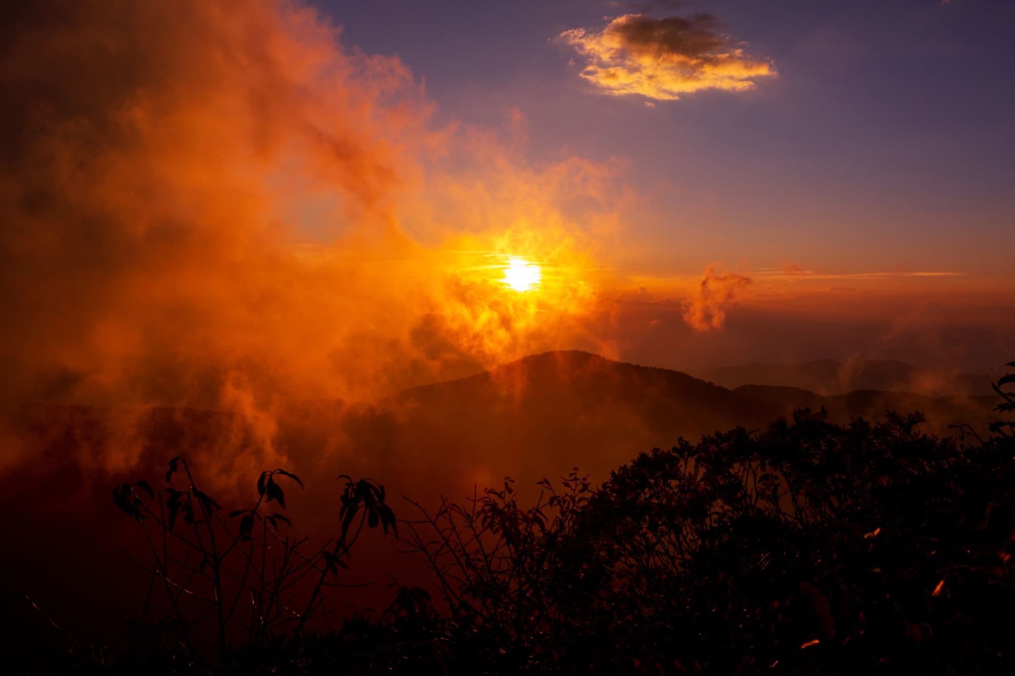 Stunning golden sunset with mist and mountains near Asheville, NC.