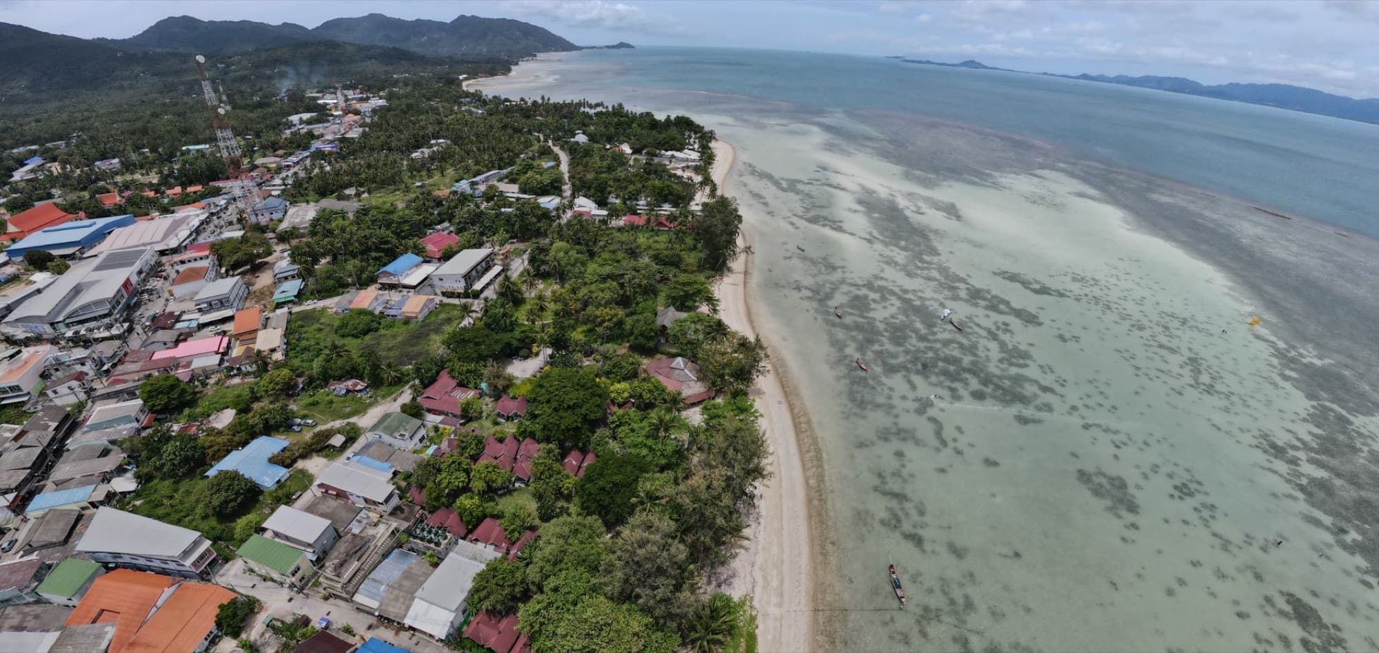 Aerial shot of a coastal town with beachfront and turquoise sea.
