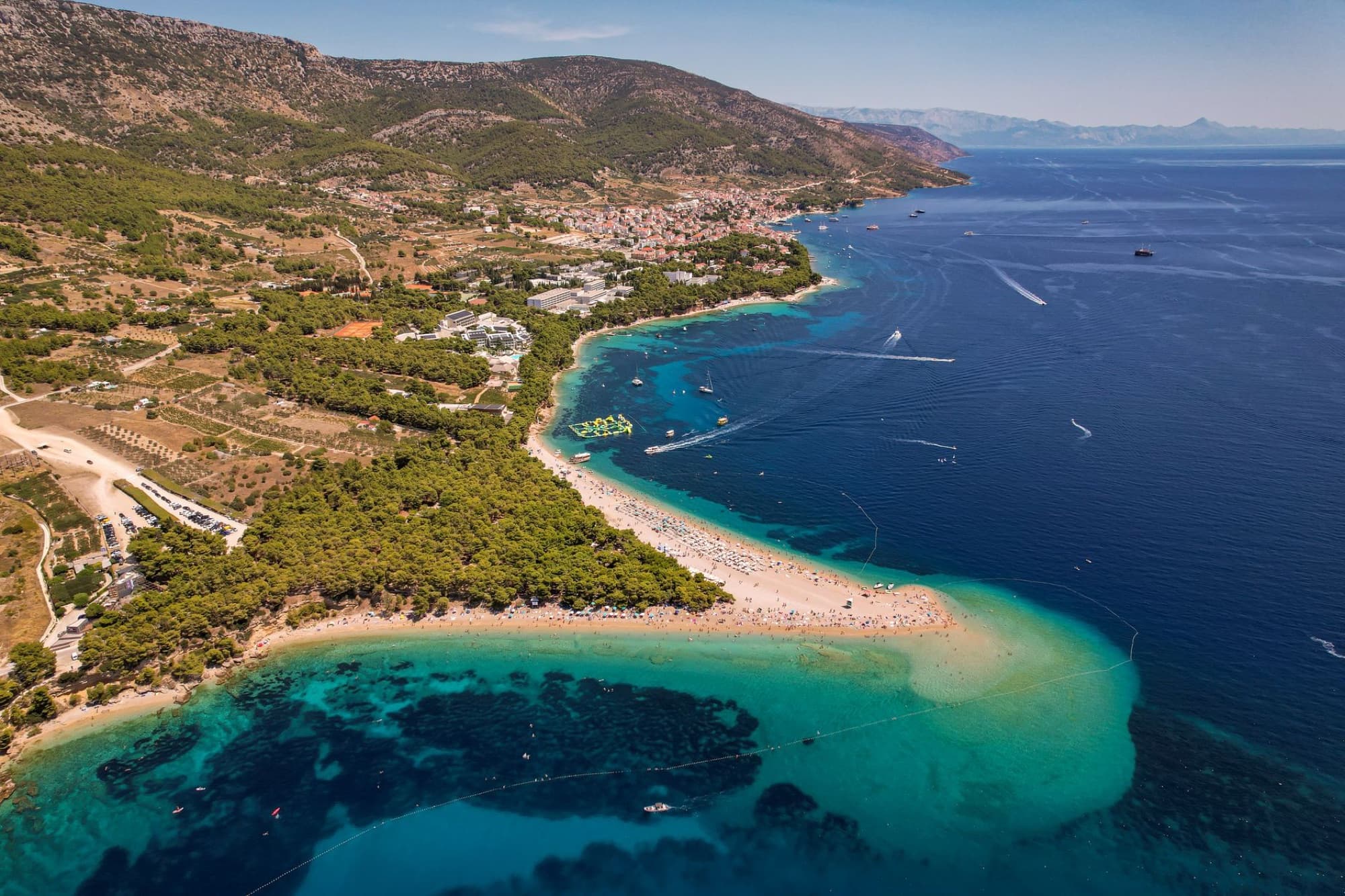 Stunning aerial view of a scenic beach with clear blue waters and vibrant landscape in summer.