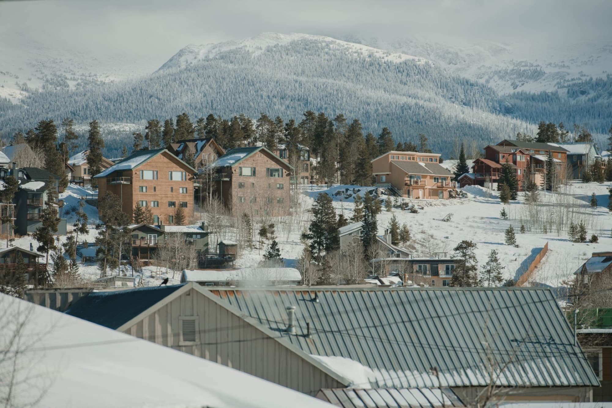 Scenic winter view of Breckenridge, Colorado with snow-covered houses and mountains.