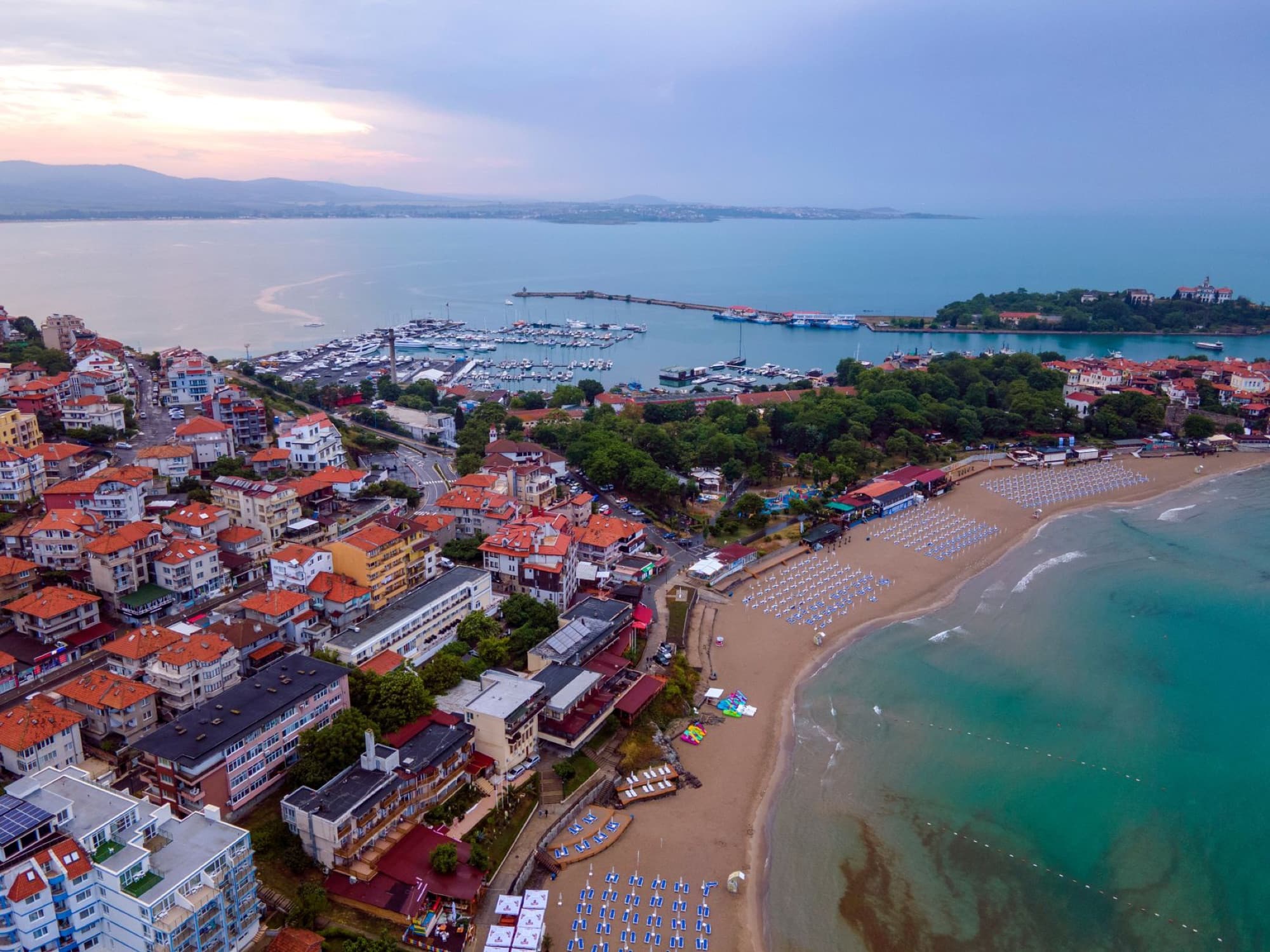 Aerial shot of Sozopol, Bulgaria showcasing the beach, town, and coastline at dawn.