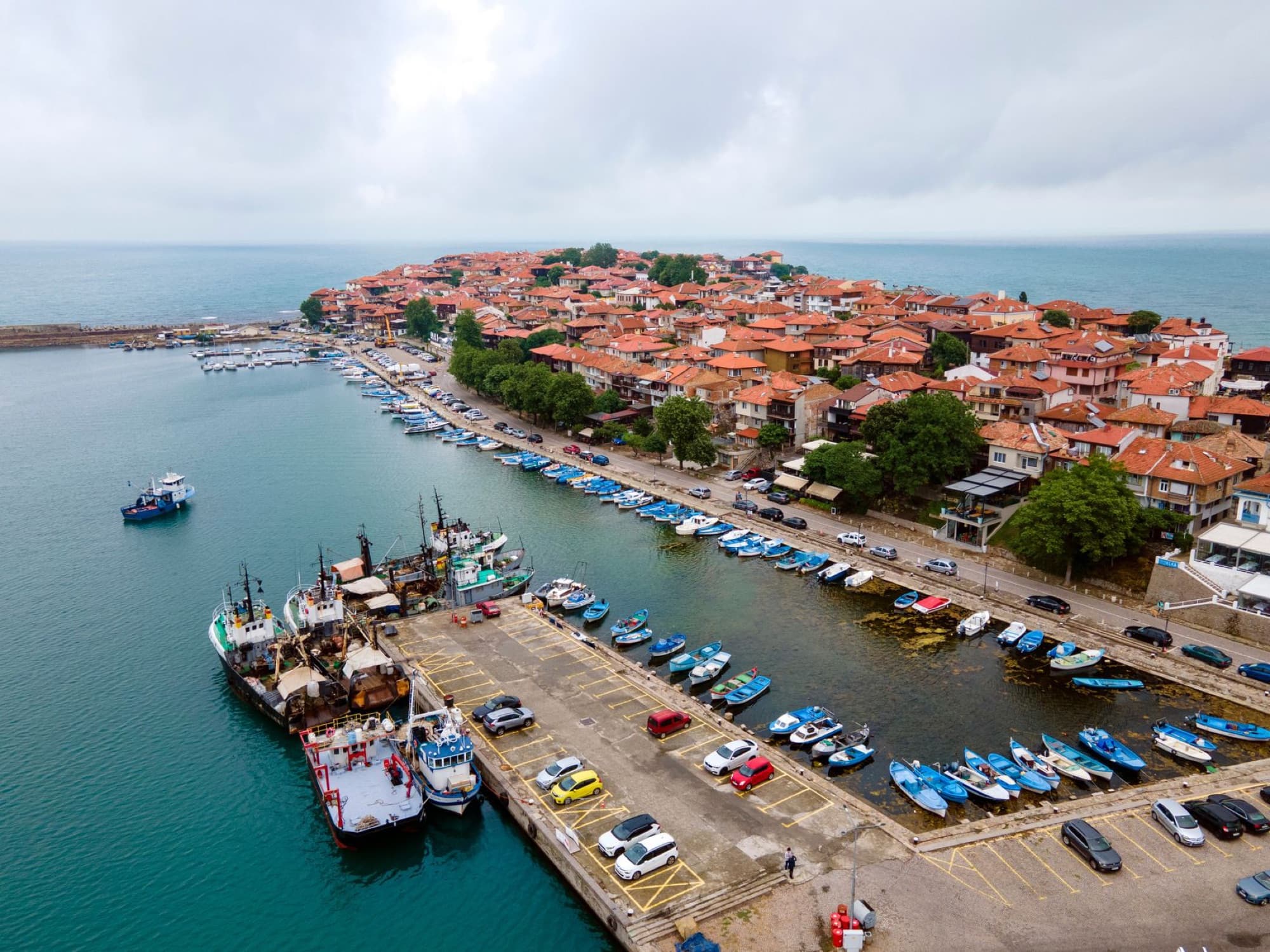 A stunning aerial shot of Sozopol harbor in Bulgaria, showcasing boats and historic town with orange rooftops.