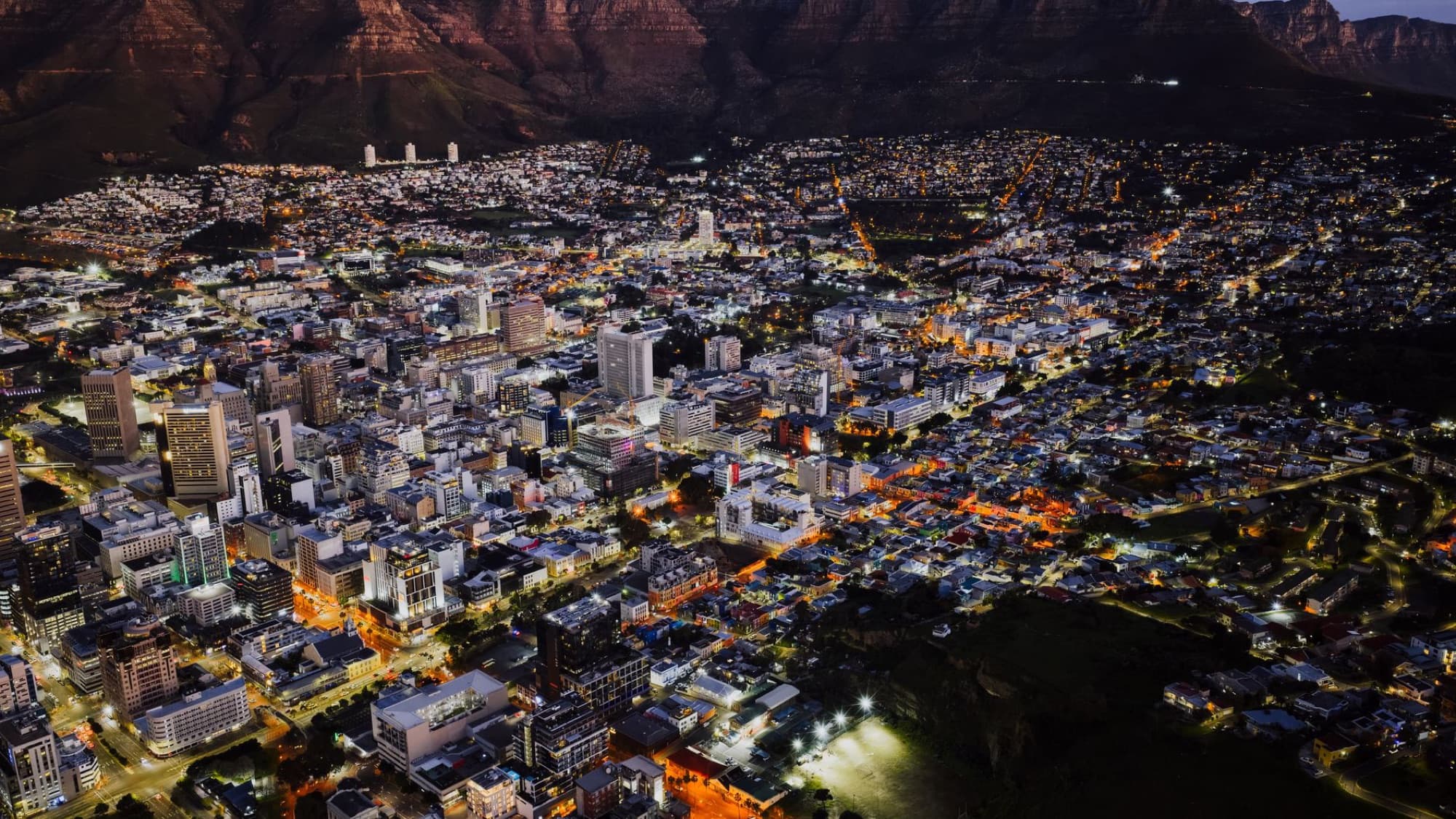 A stunning aerial view of Cape Town city lights at night against Table Mountain.