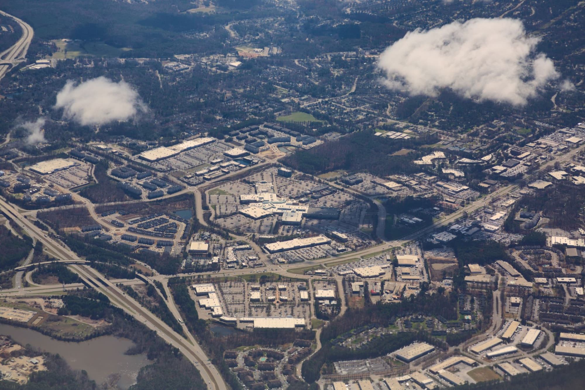 Stunning aerial view of Raleigh, NC showcasing city layout, roads, and clouds.