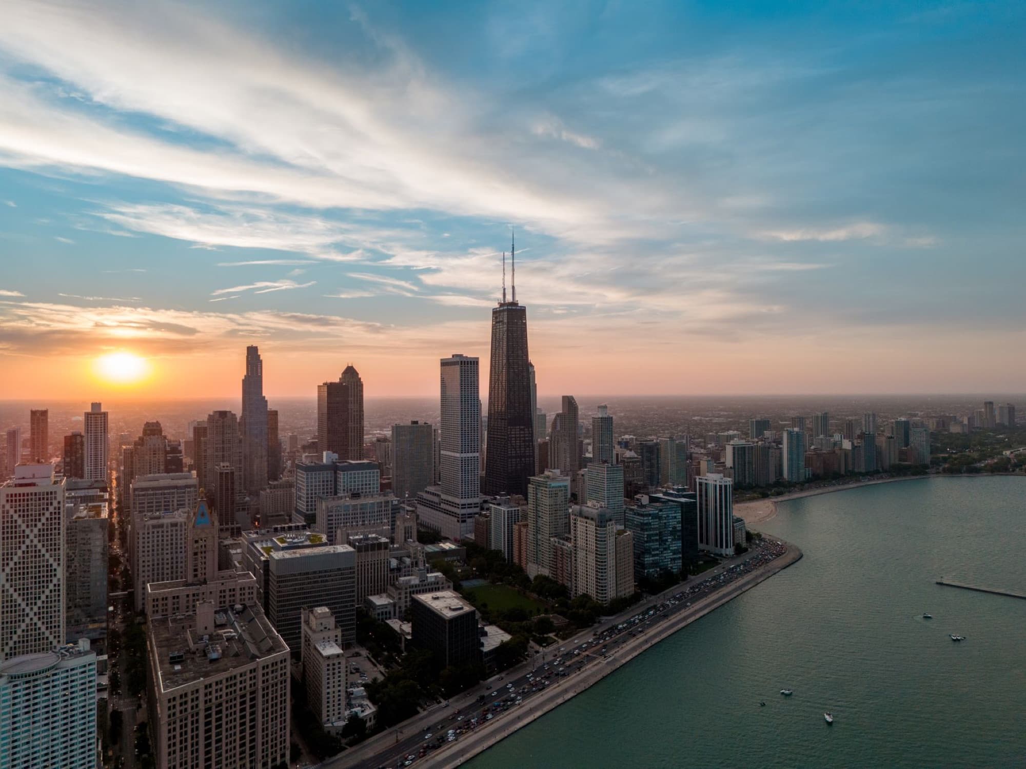 Aerial view of Chicago skyline with Willis Tower at sunset over Lake Michigan.