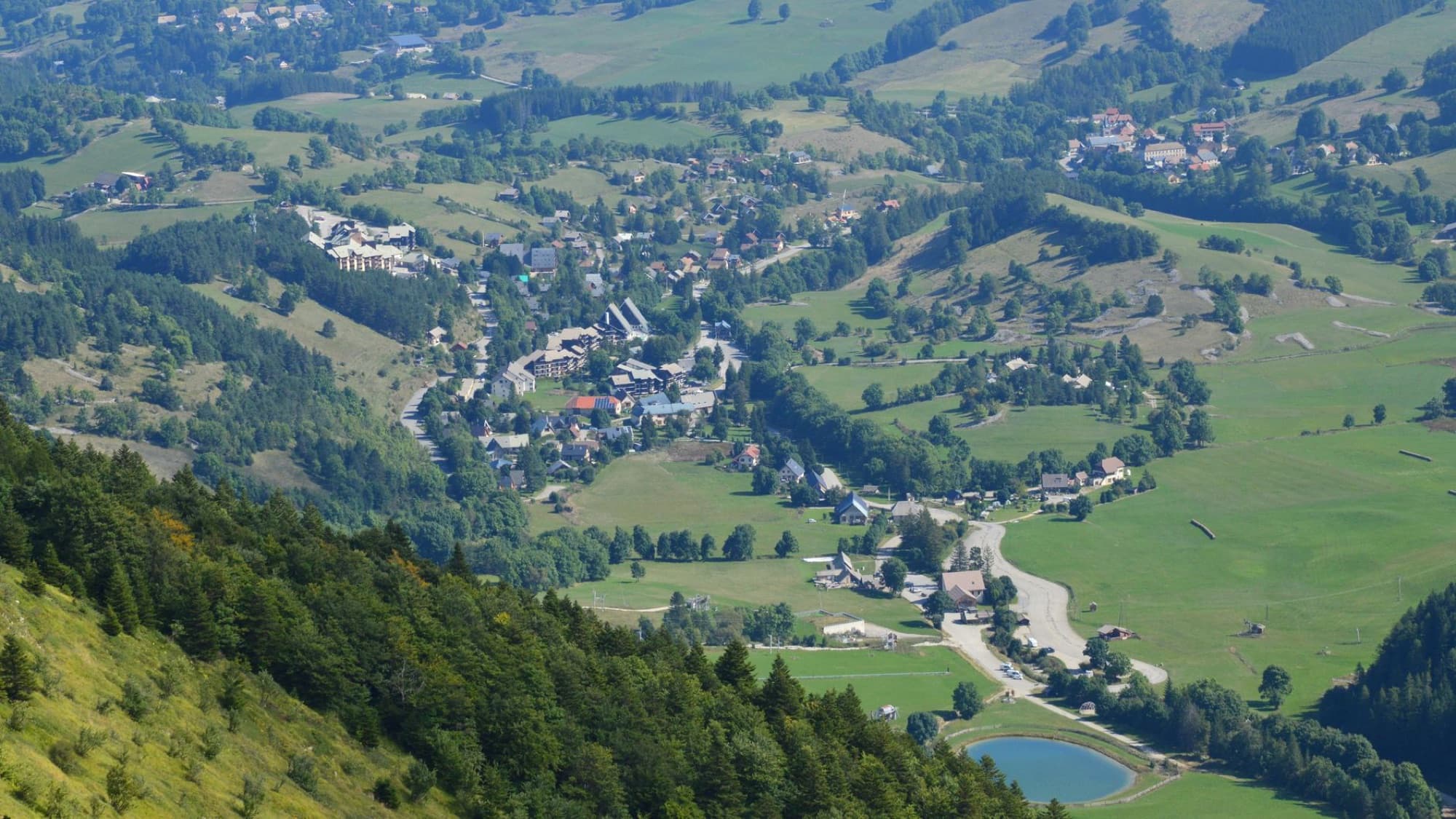 Scenic aerial view of Gresse-en-Vercors village in France surrounded by lush greenery.