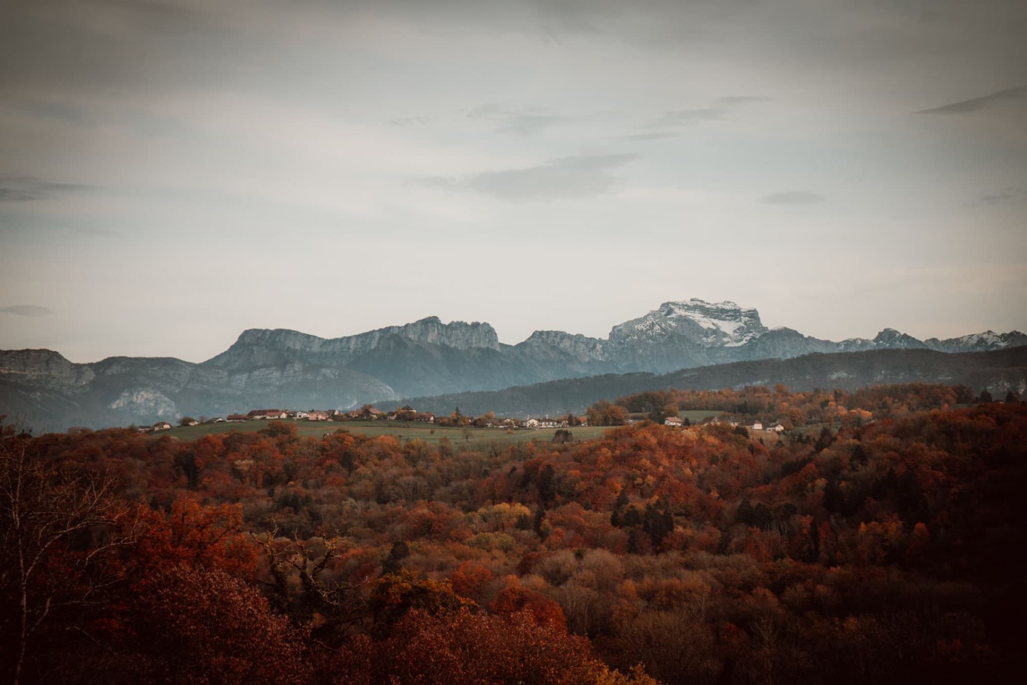 Stunning autumn landscape of the French Alps with colorful forests and mountain peaks.