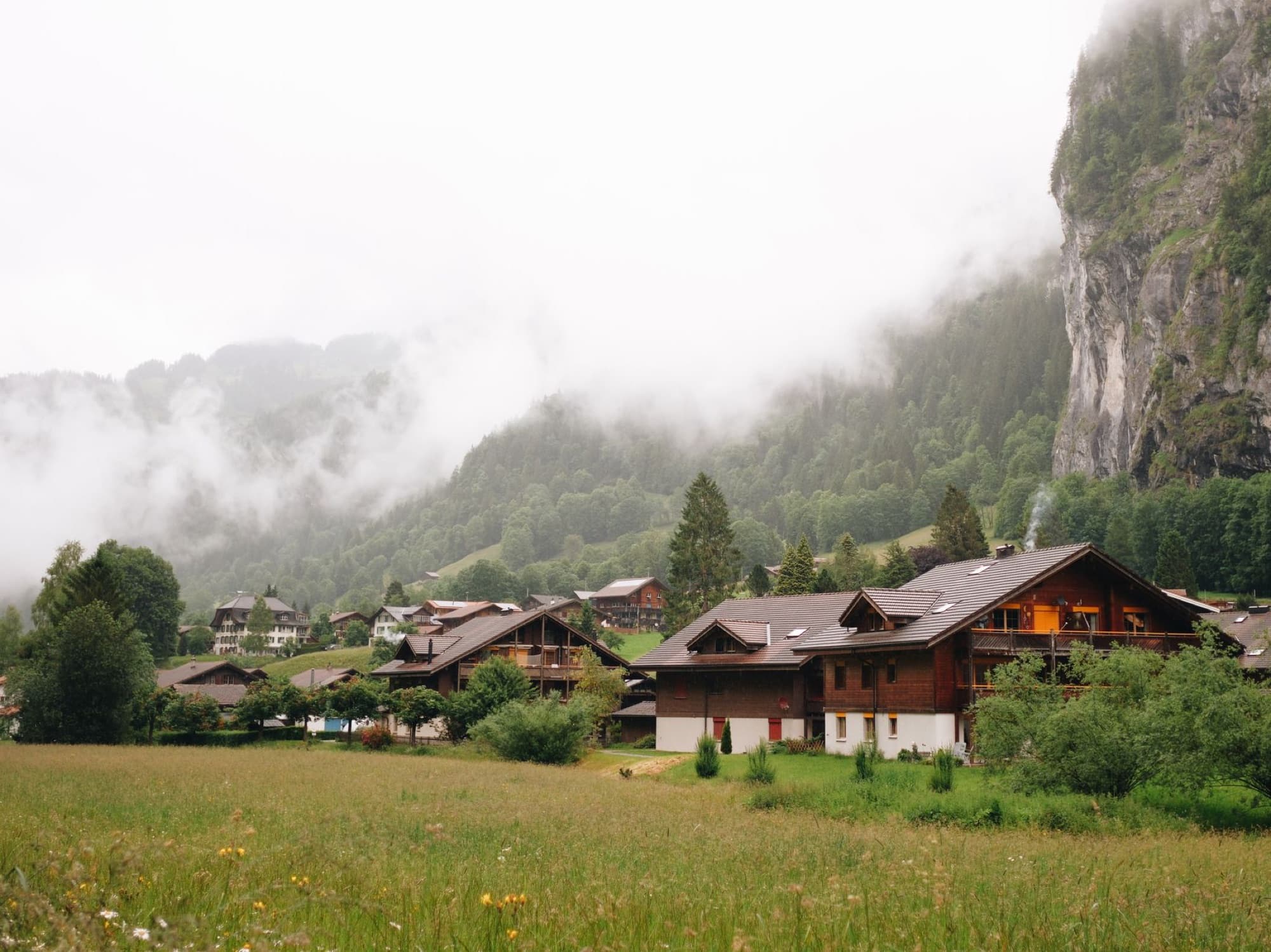 Picturesque mountain village with wooden houses and misty landscape, perfect for travel inspiration.