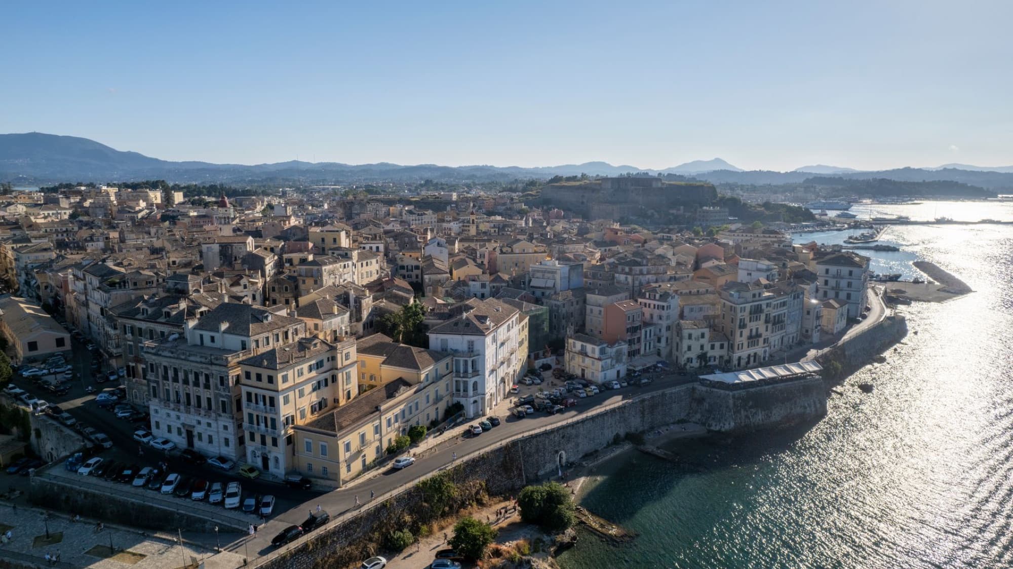 Aerial view of Corfu Town, Greece, highlighting historical architecture along the coast.