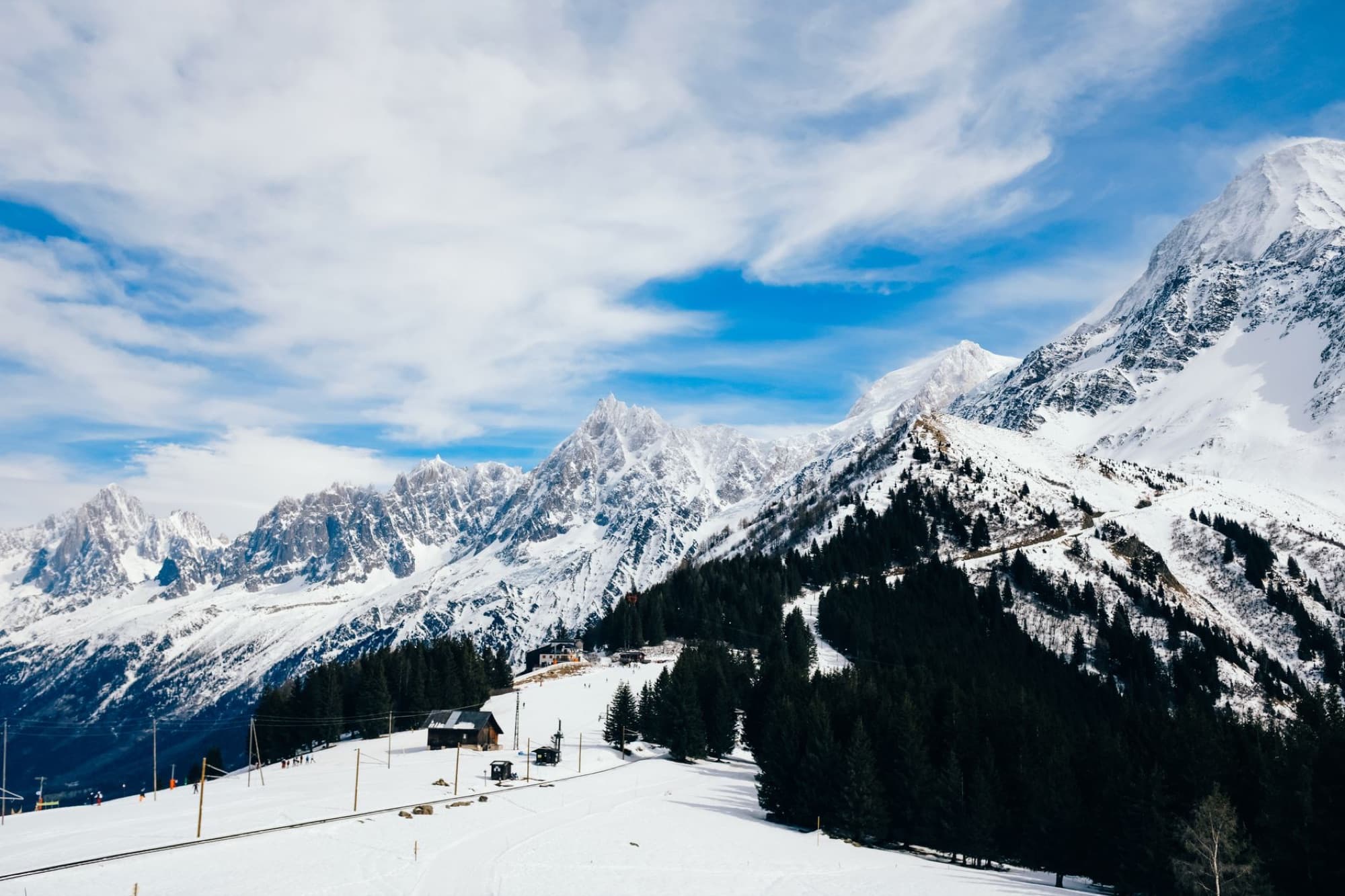 Scenic view of a snowy mountain landscape featuring rugged peaks and clear blue sky.