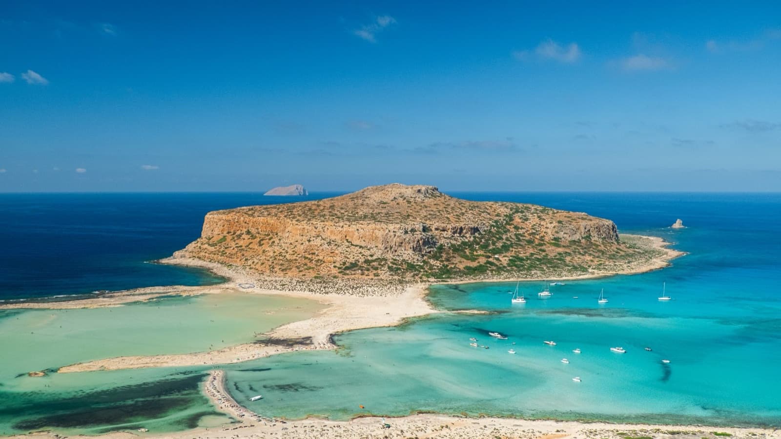 A stunning aerial capture of Balos Lagoon in Crete, showcasing turquoise waters and a rocky island.