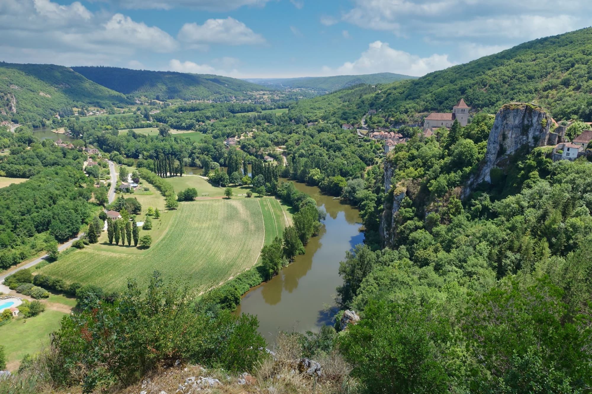 A breathtaking aerial view of lush landscapes and a winding river in rural France.