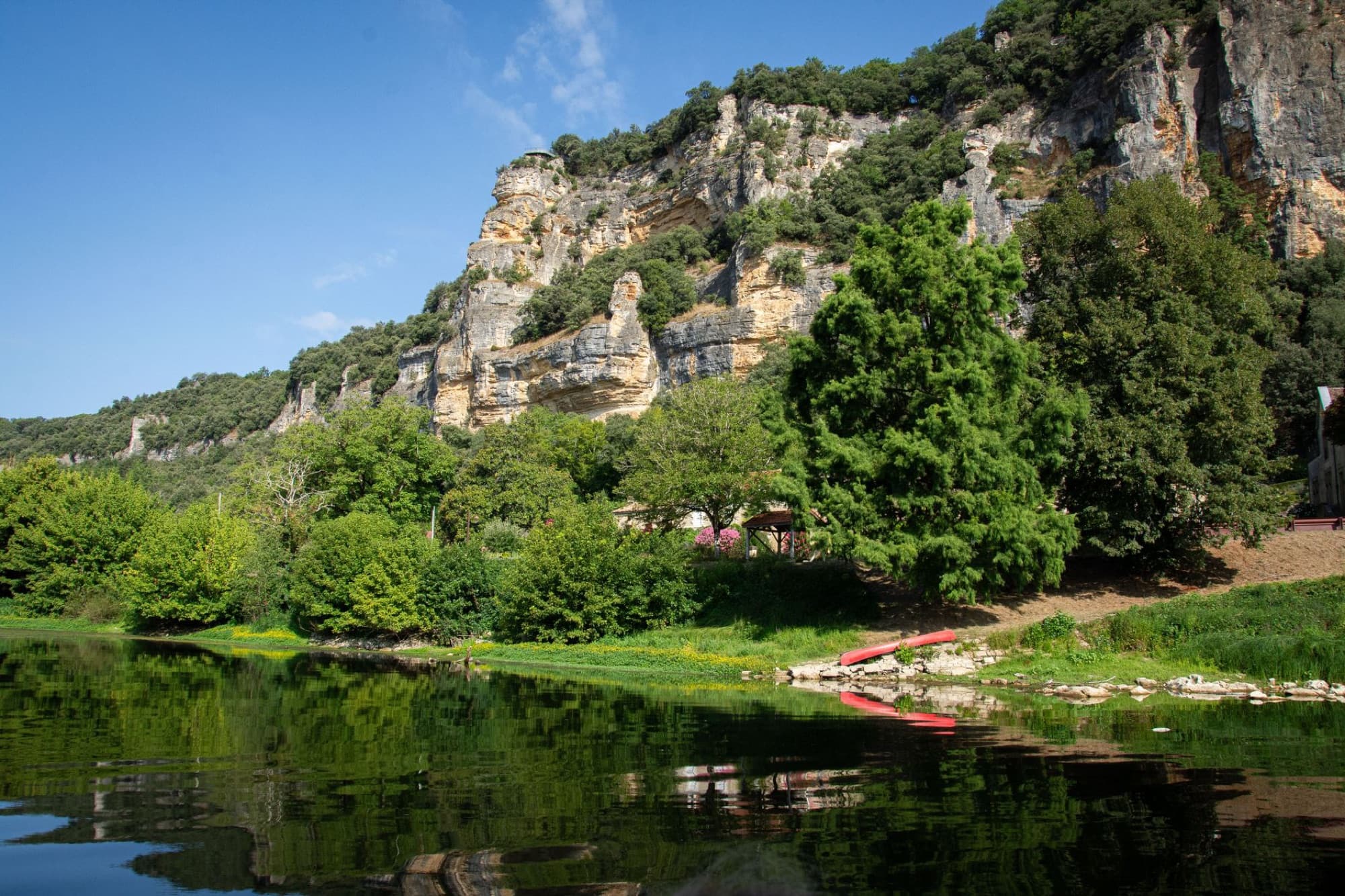 Beautiful landscape of Dordogne River with towering cliffs and lush greenery.