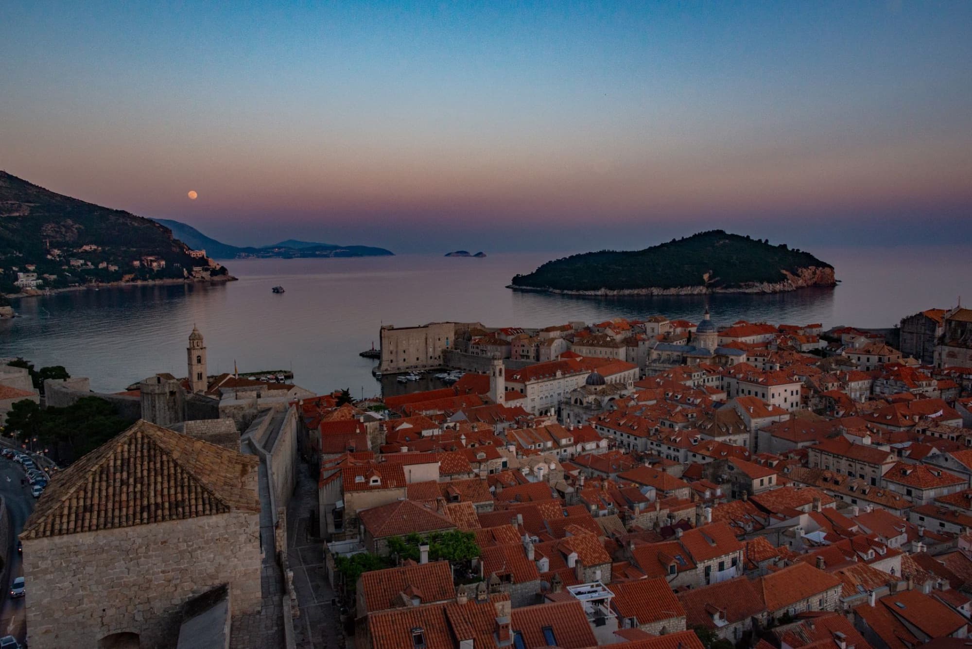 Stunning aerial shot of Dubrovnik's coastline at sunset, showcasing the city's historic architecture and Adriatic Sea.