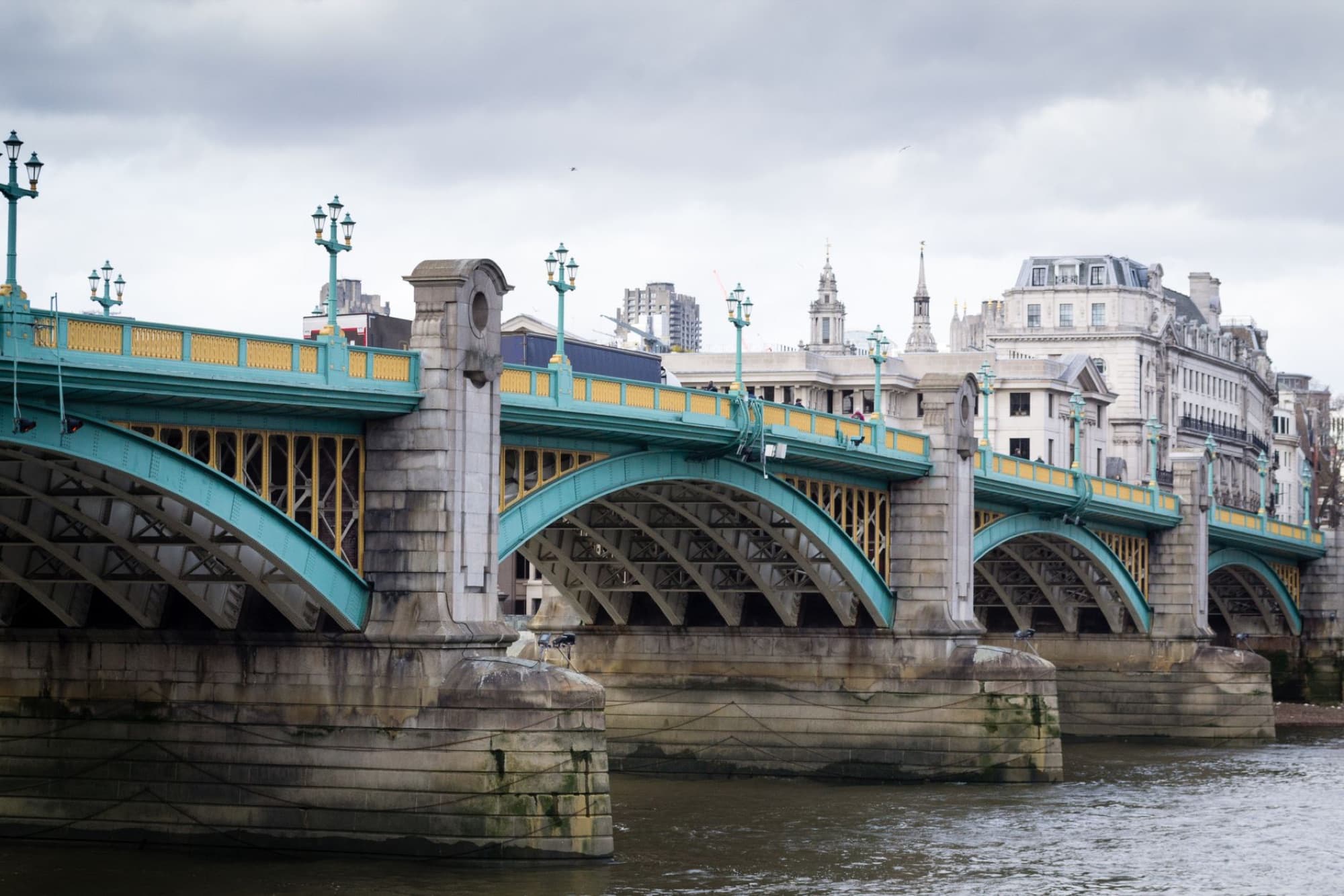 A beautiful view of Southwark Bridge spanning the Thames River in London, England.