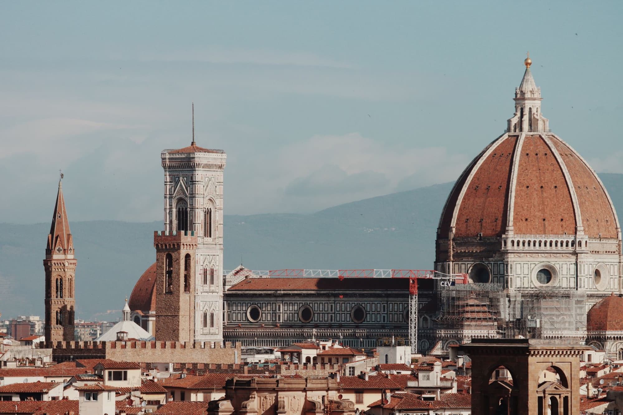 Aerial view of Florence's iconic cathedral and towers under a clear sky.