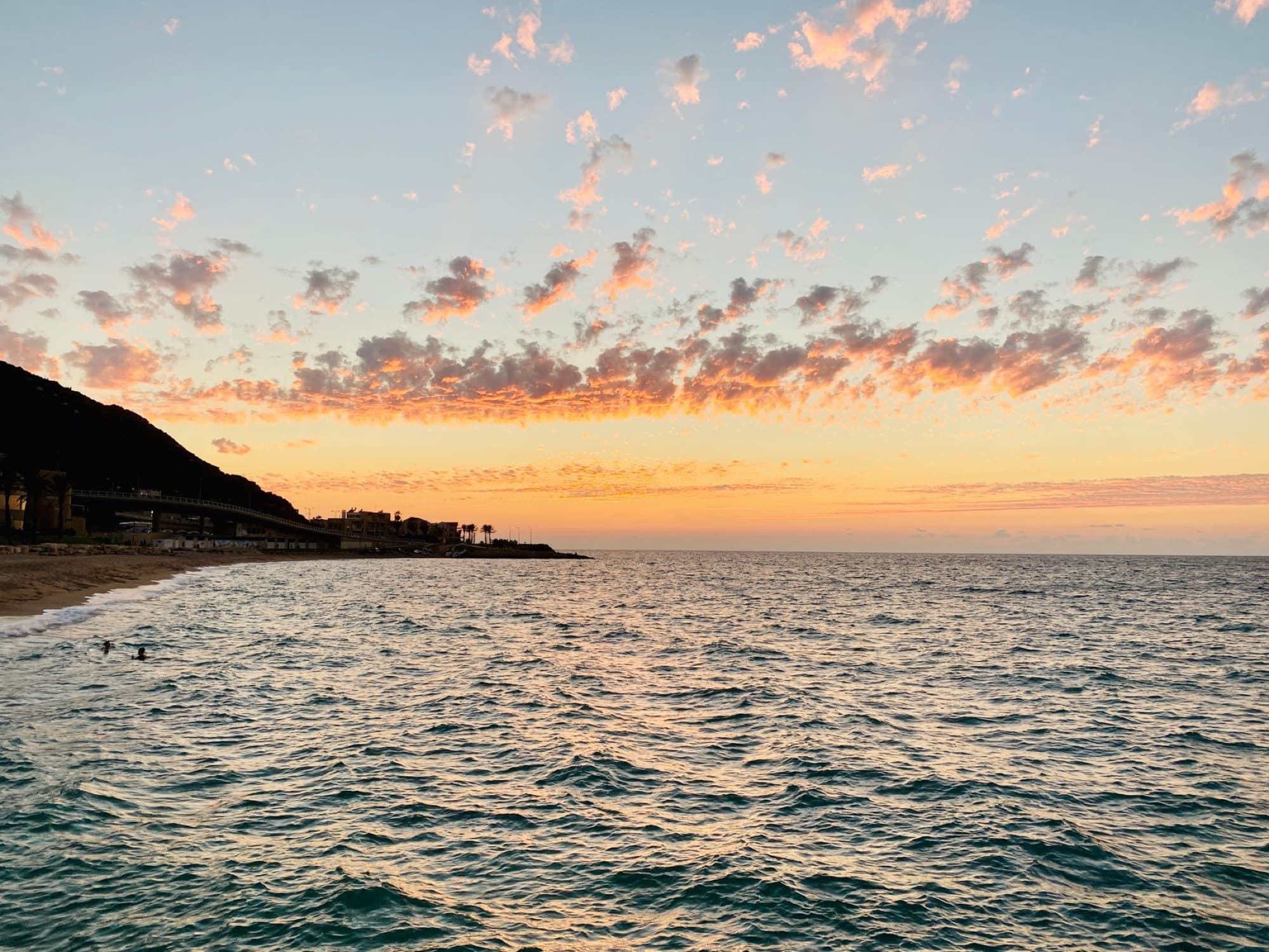 Breathtaking sunset over Haifa beach with colorful clouds and tranquil sea view.