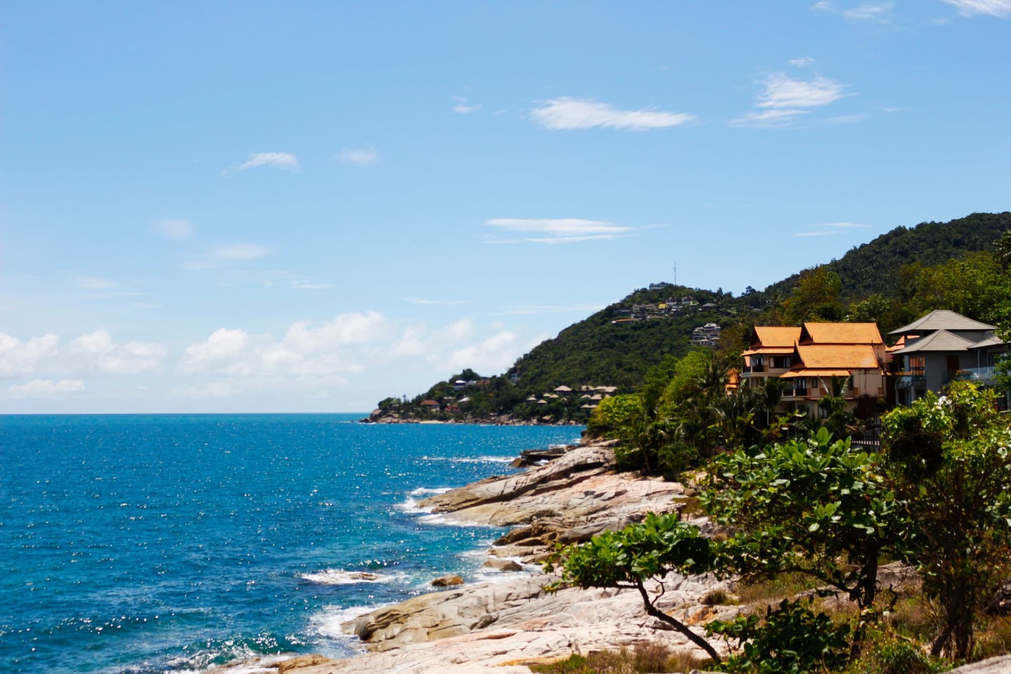 Explore the stunning coastal view of Koh Samui with lush greenery and bright blue sea.