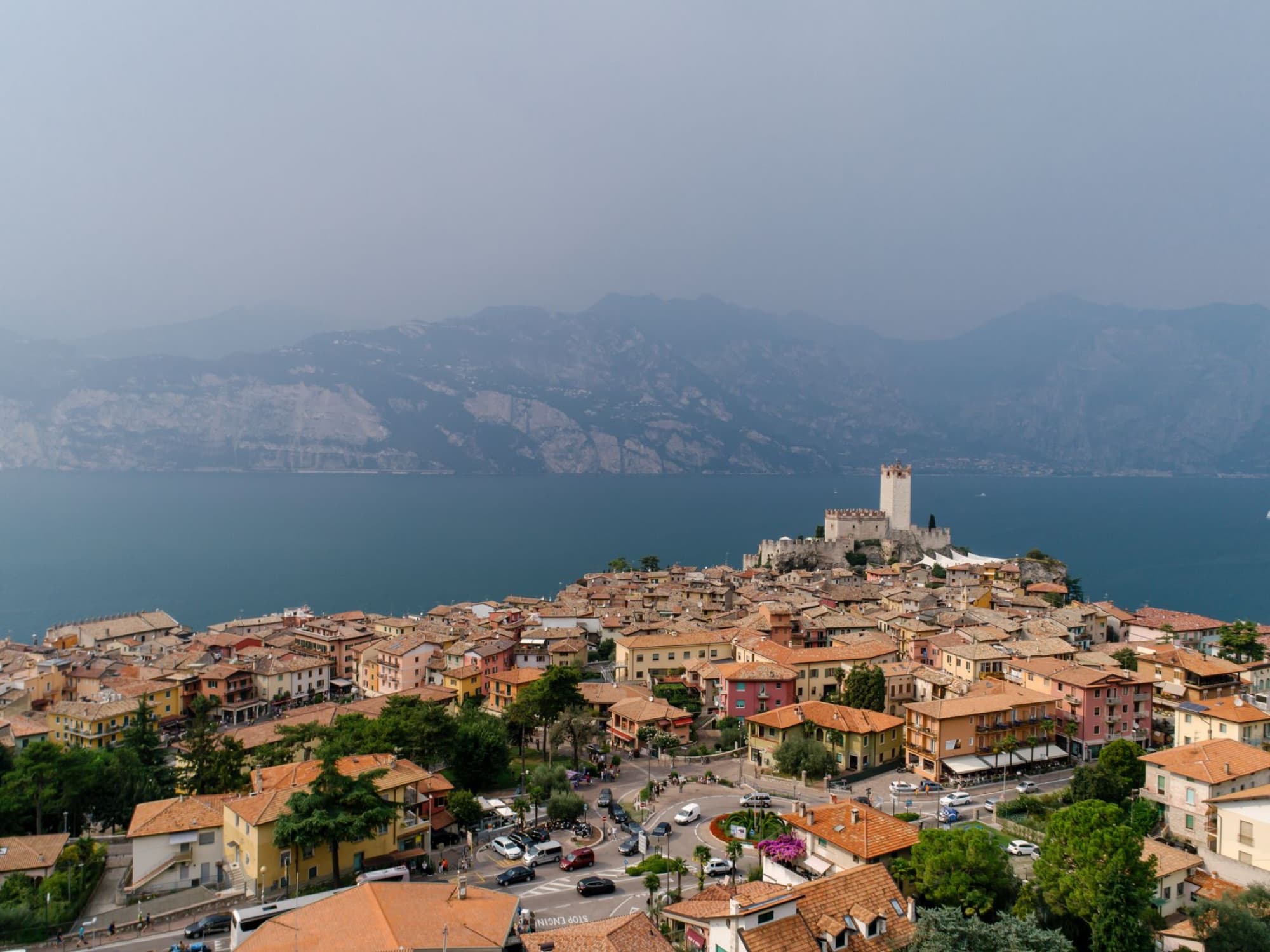 Aerial view of Malcesine town on Lake Garda, Italy, with its historic castle and picturesque landscape.