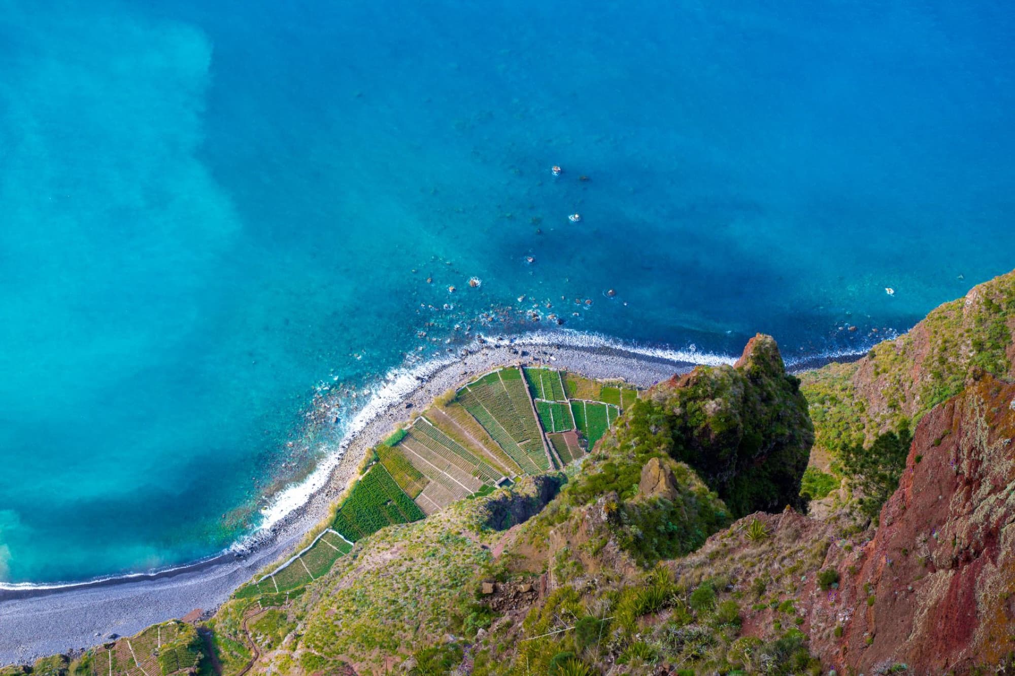 Stunning aerial shot of Câmara De Lobos coastline, Madeira, showcasing vibrant ocean and rugged landscape.