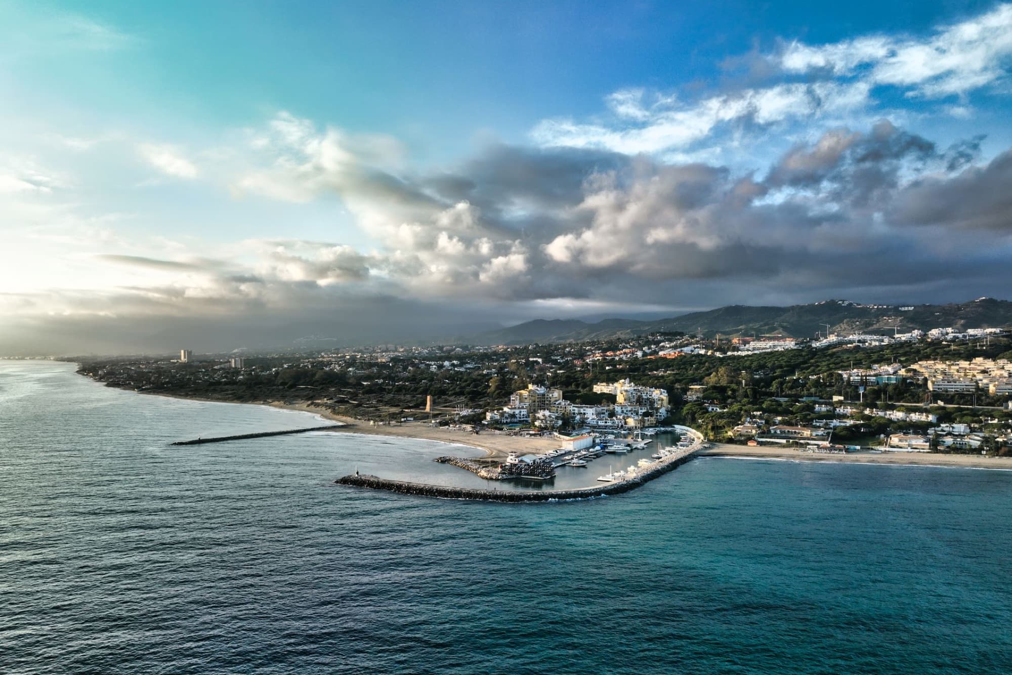 Breathtaking aerial view of Marbella, Spain with a scenic coastal and mountainous horizon.