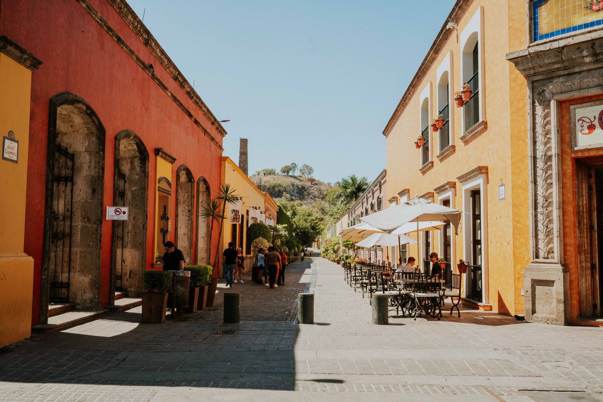 Colorful street scene in Tequila, Jalisco, showcasing vibrant buildings under a clear sky.