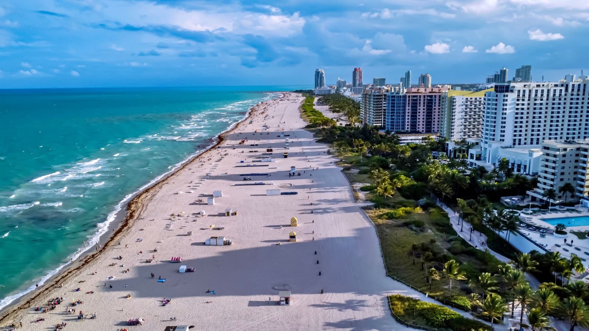 Aerial shot of Miami Beach showcasing the coastline, city skyline, and vibrant sea.