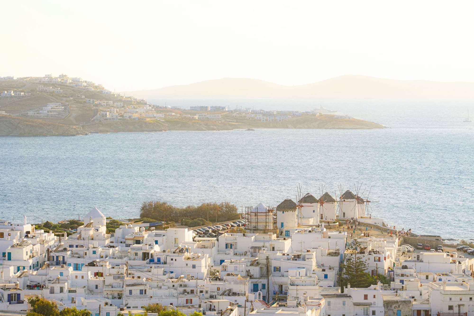 A beautiful aerial view of Mykonos, showcasing traditional white buildings and famous windmills by the sea.