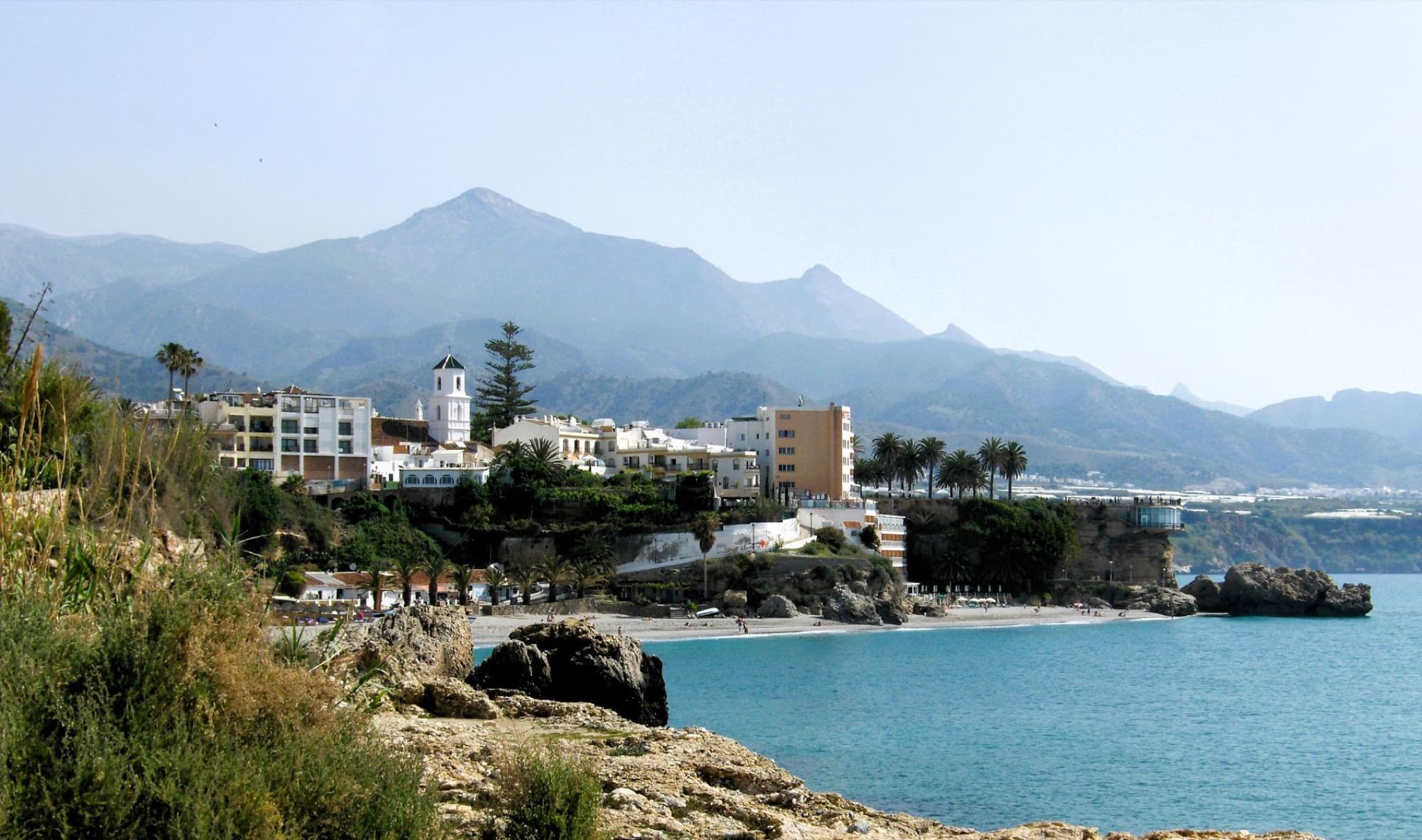 Picturesque coastal town of Nerja with stunning mountains and clear blue sea.