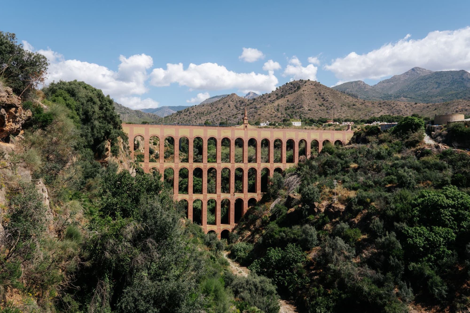 A stunning view of the Eagle Aqueduct set against the mountainous landscape of Nerja, Spain.