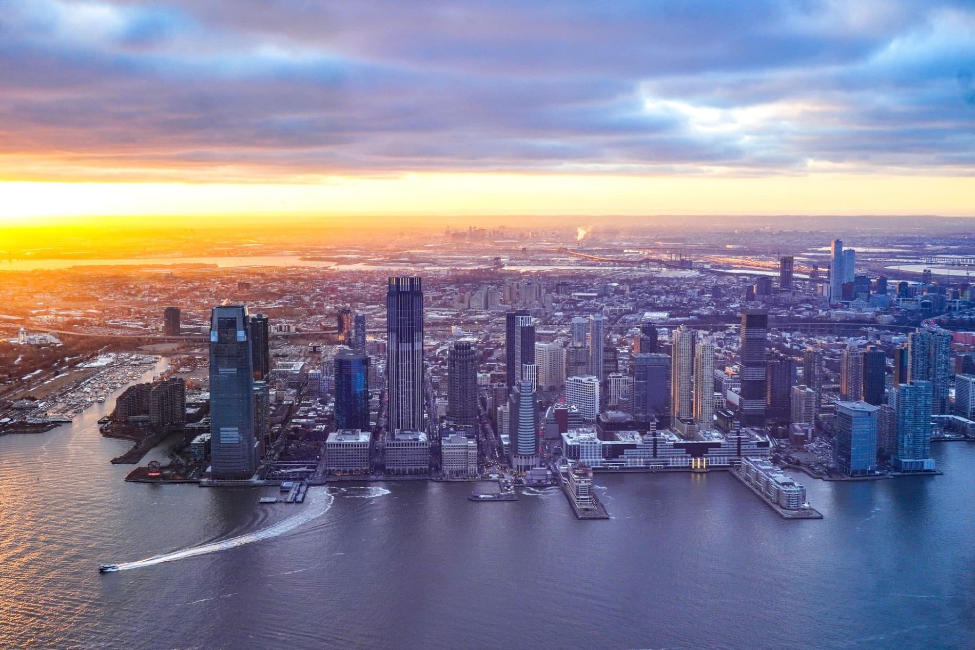 Breathtaking aerial view of Jersey City's modern skyline at sunset with vibrant colors and skyscrapers.