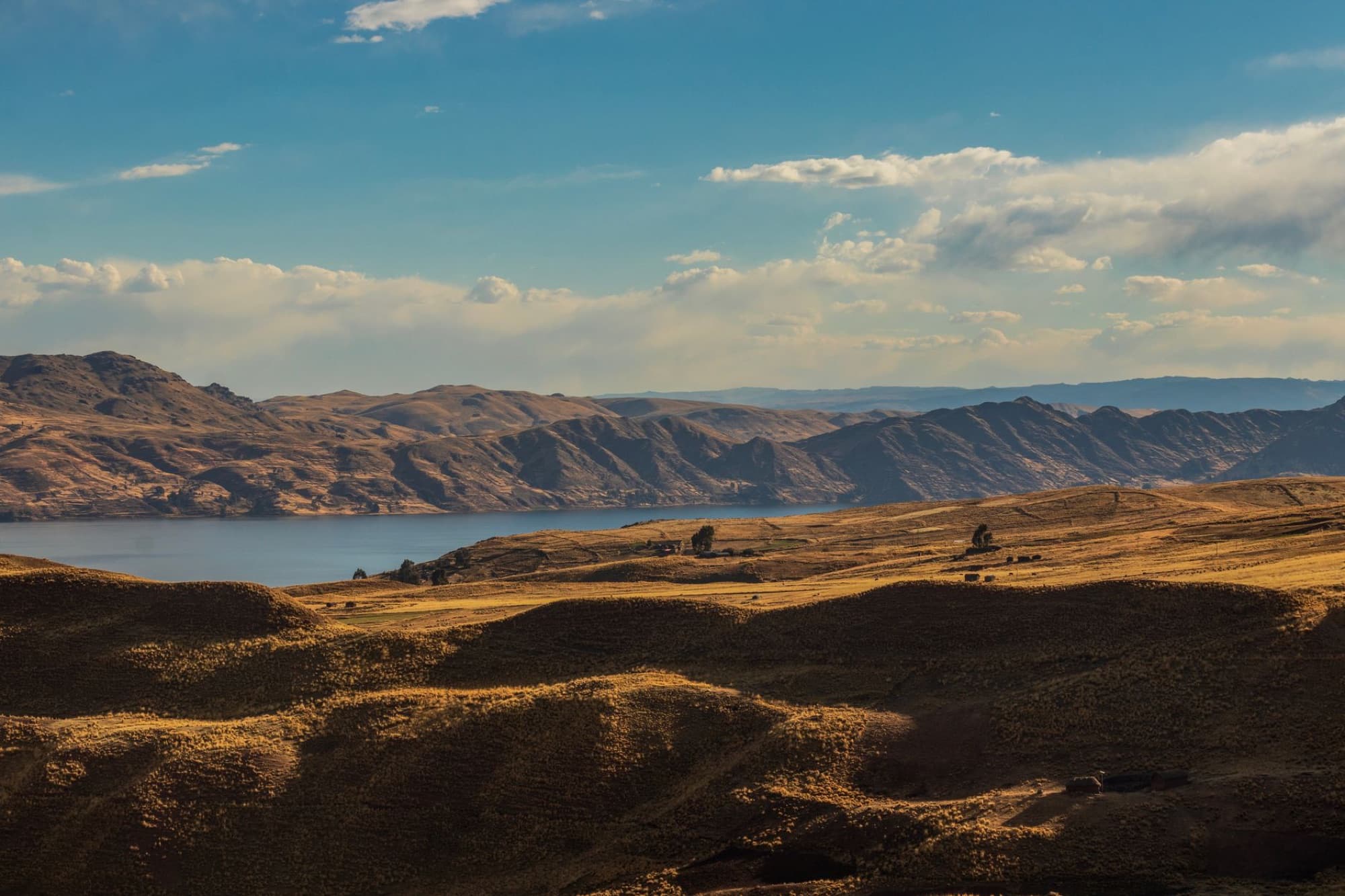 Beautiful landscape of Lake Langui Layo in Cuzco, Peru framed by mountains and a serene sky.