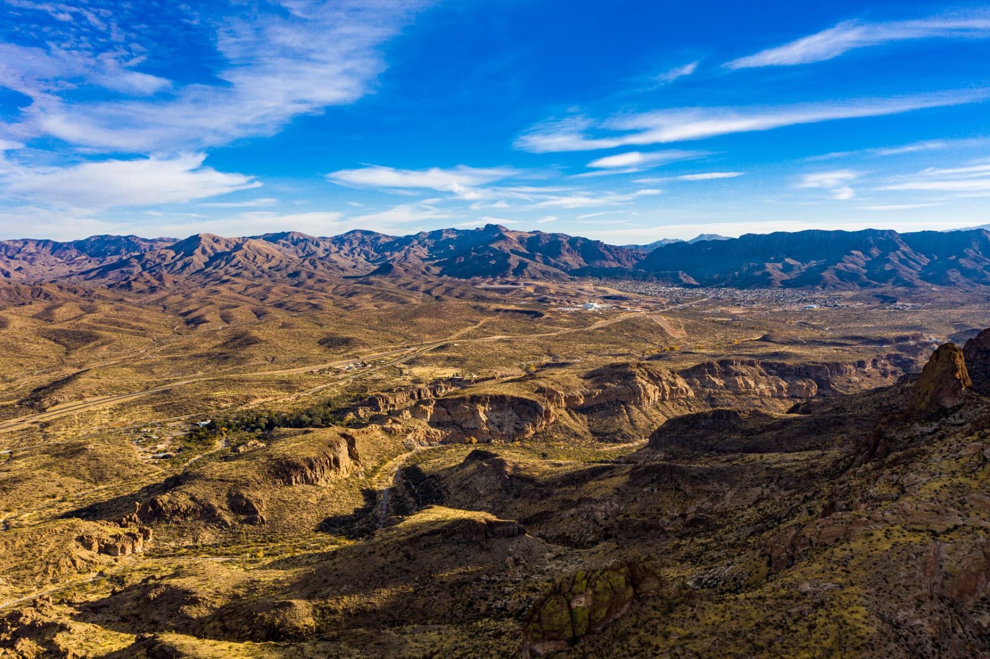 Stunning aerial view of rugged desert mountains under a vast blue sky.