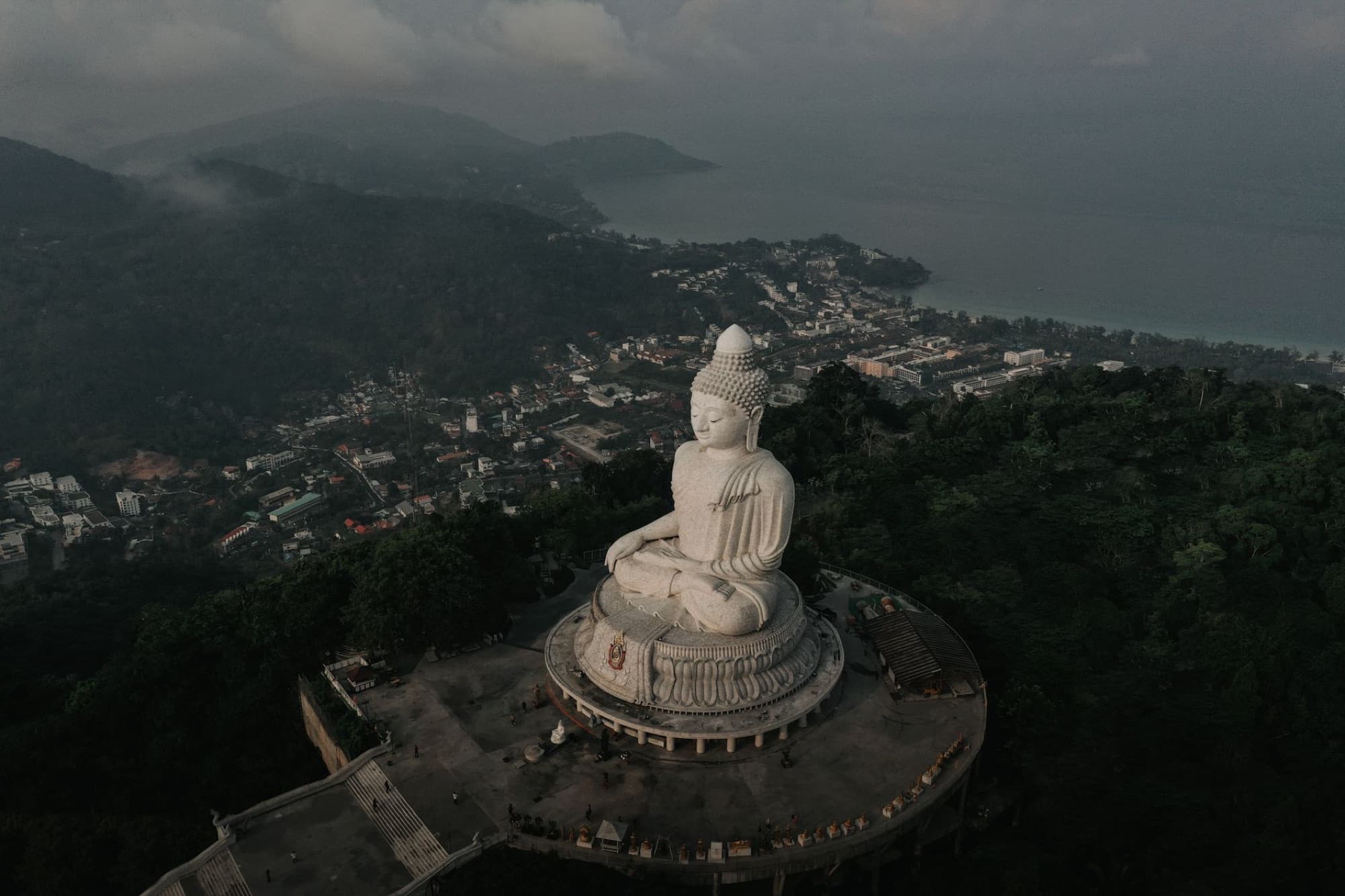 Captivating aerial shot of the iconic Big Buddha statue overlooking Phuket, Thailand's lush landscape.