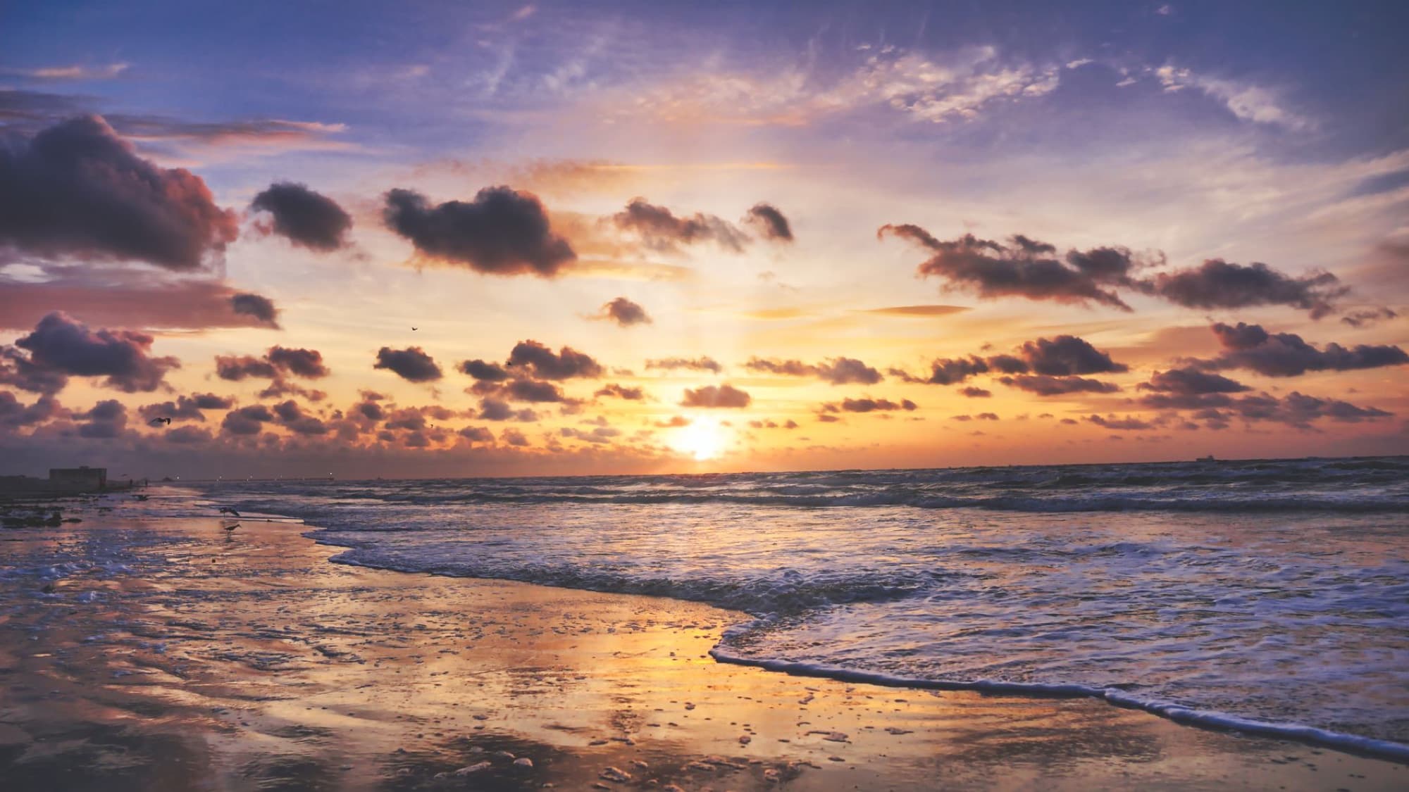 Capture of a breathtaking sunset over the waves at Port Aransas, Texas. Vibrant sky and reflective water.