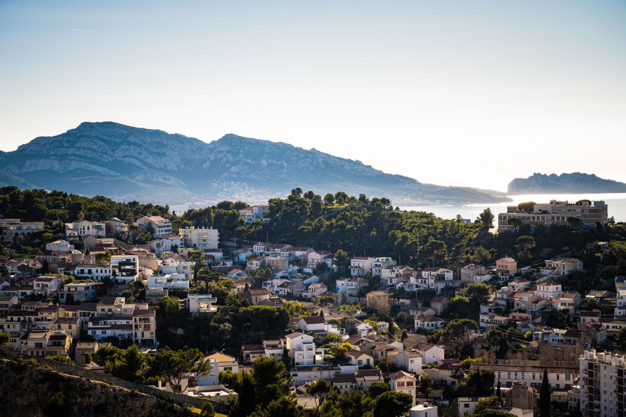 Aerial view of Marseille, France showing urban landscape against a mountain backdrop at daytime.