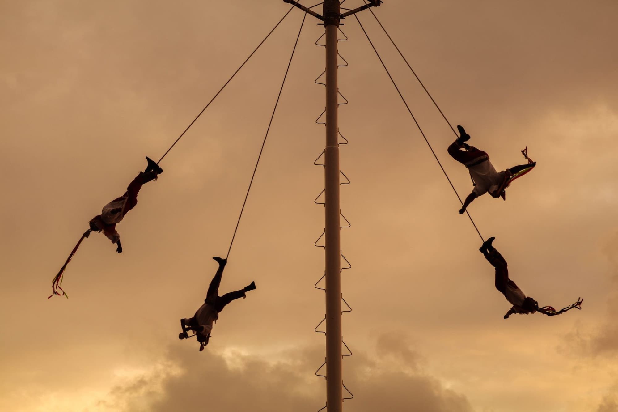 Voladores performing an aerial acrobatic dance at sunset in Puerto Vallarta, Mexico.