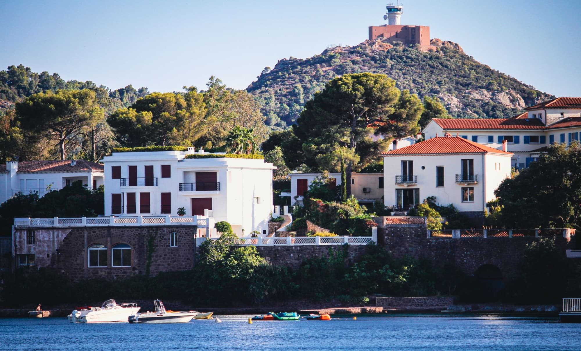 Charming coastal village in the Mediterranean with a hilltop lighthouse and serene atmosphere.