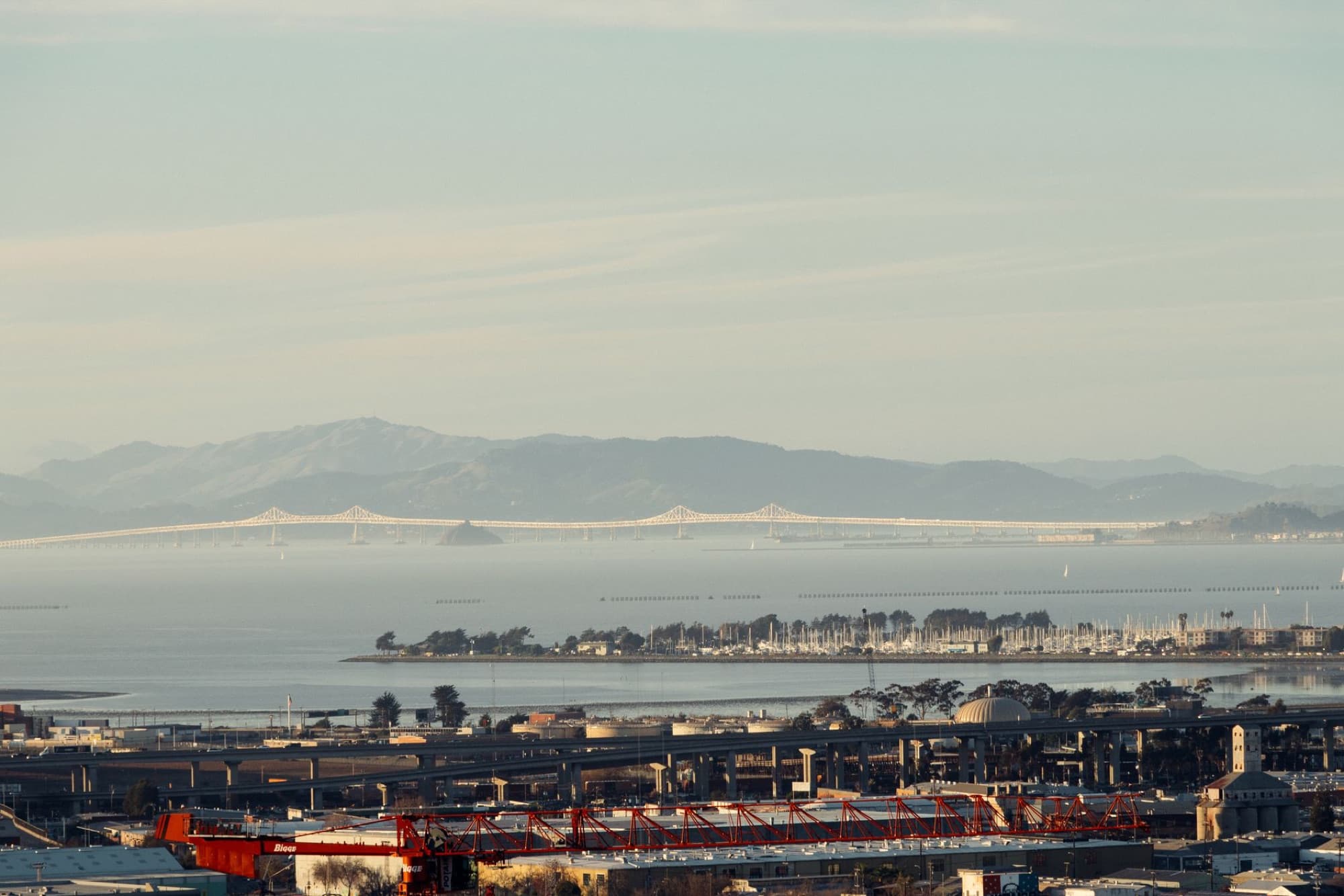 Scenic view of San Francisco Bay and bridge with cityscape and mountains.