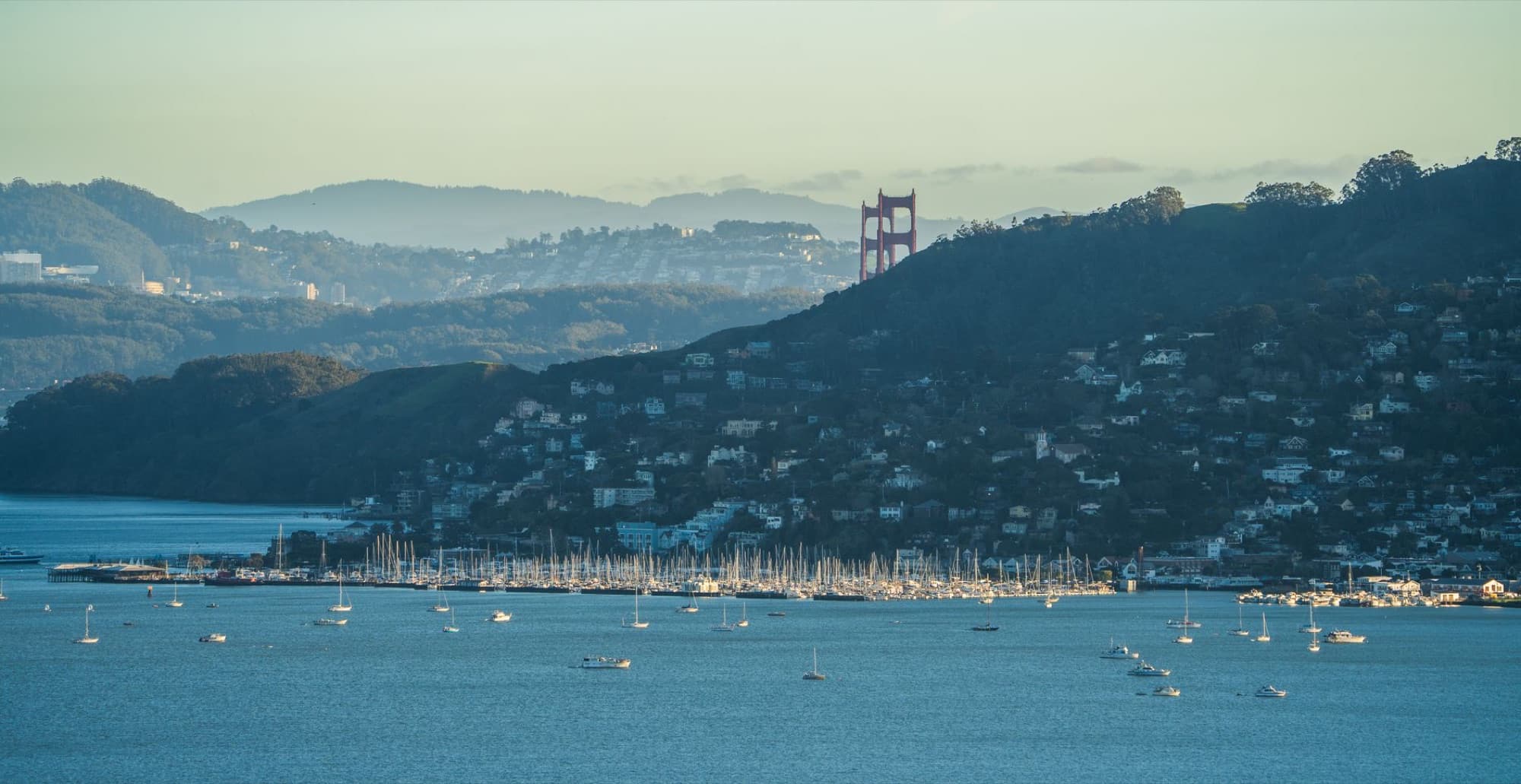 Scenic view of Golden Gate Bridge over San Francisco Bay with yachts in the foreground.