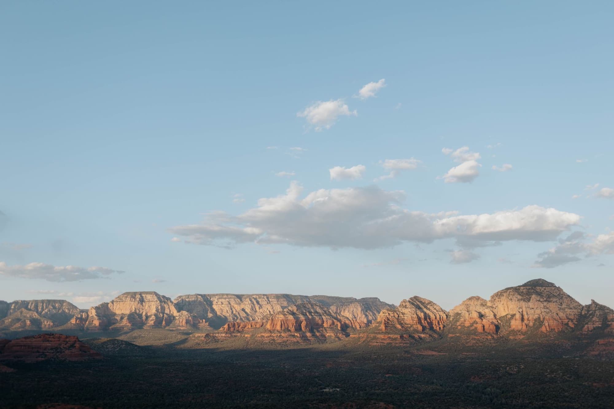 Aerial perspective of Sedona's iconic red rock formations under a clear blue sky.