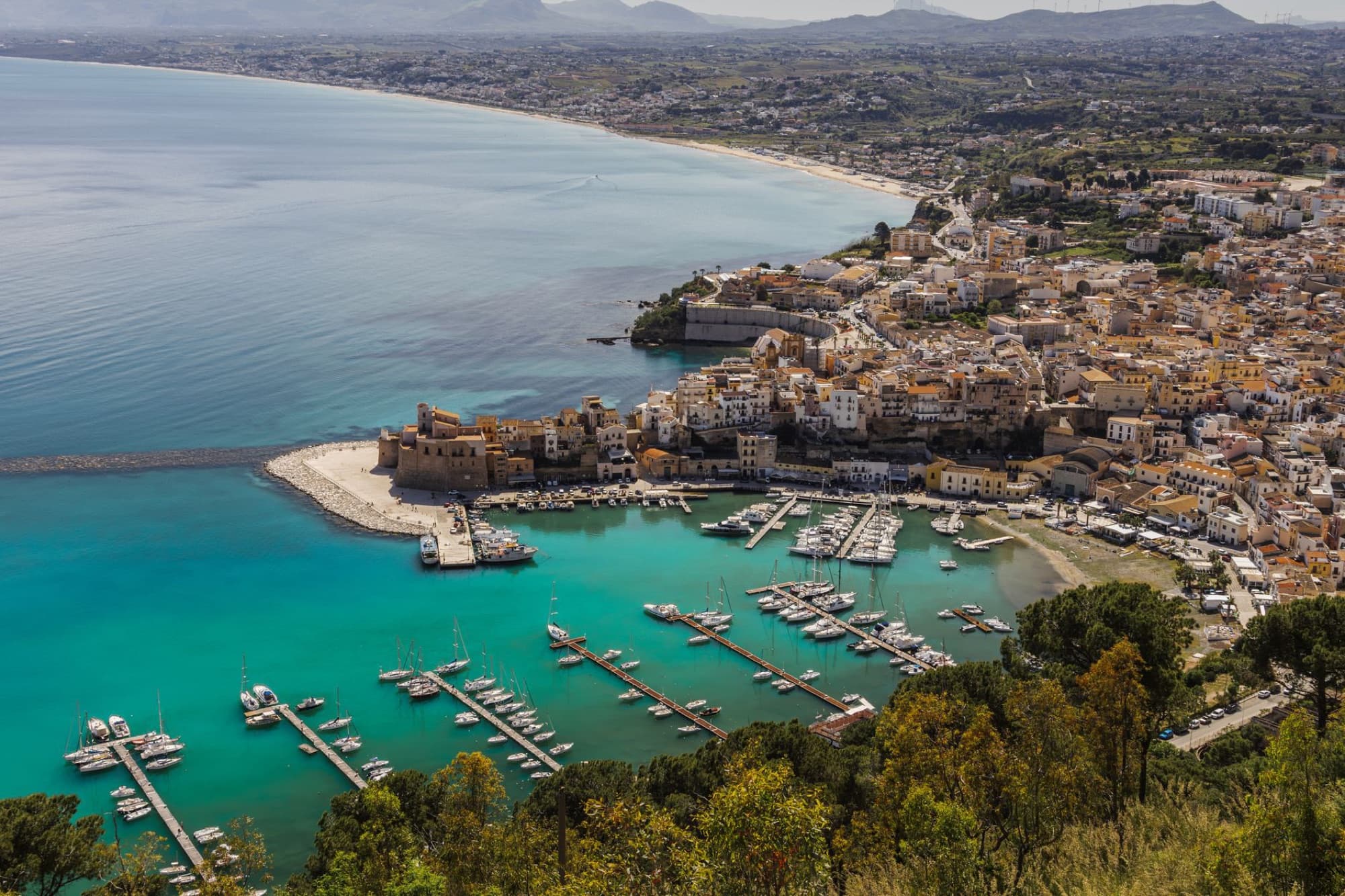 Breathtaking aerial shot of Castellammare del Golfo's vibrant harbor and coastline in Sicily, Italy.