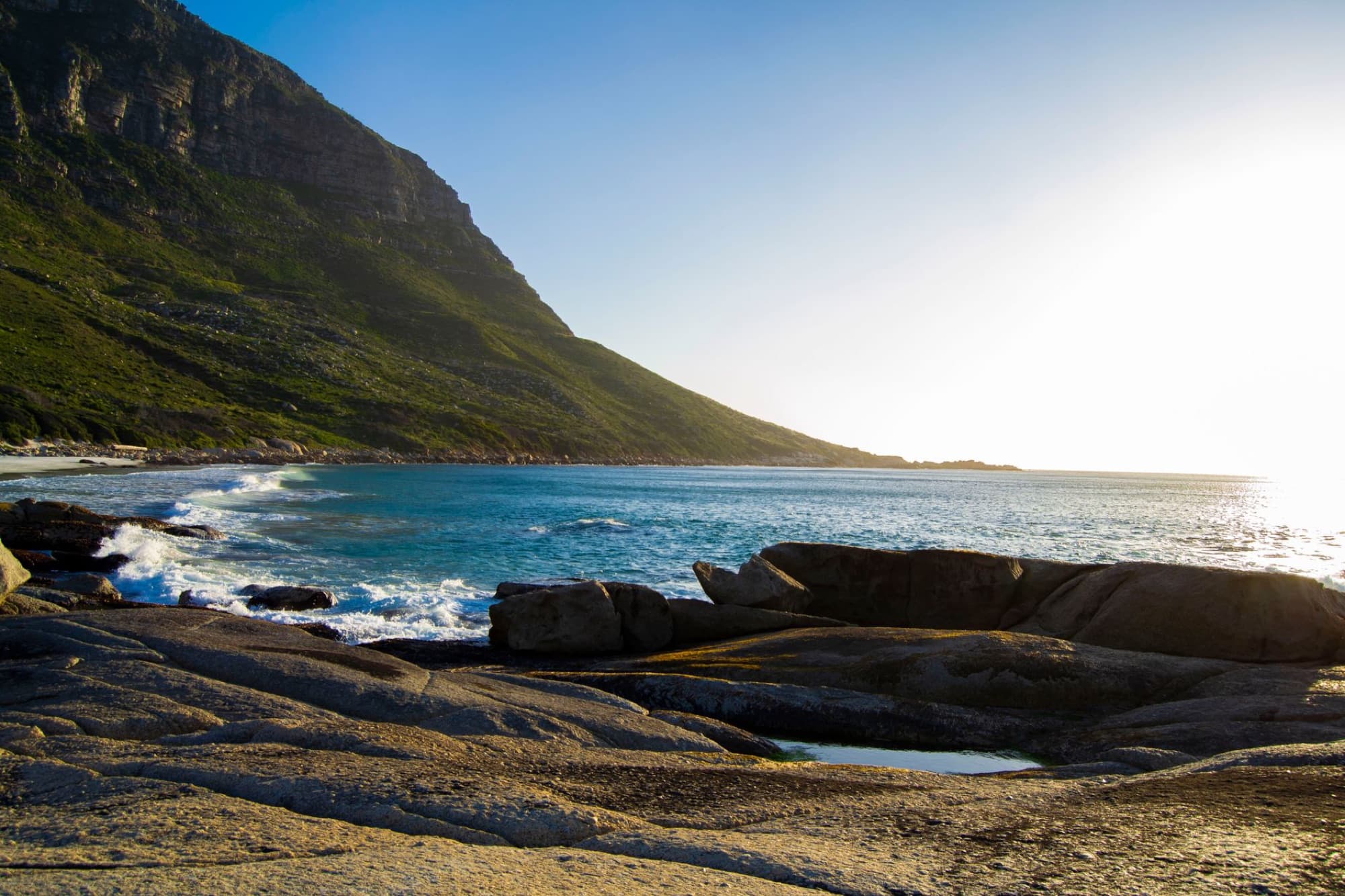 Tranquil coastal landscape of a rocky shore with mountains in South Africa.