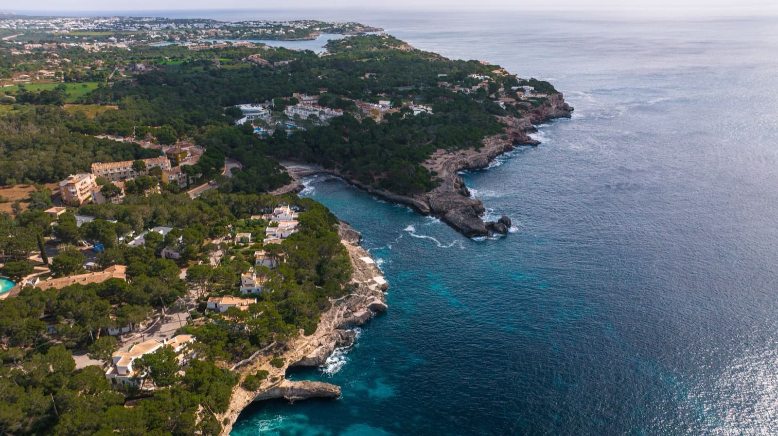 A breathtaking aerial view of Mallorca's rugged coastline and crystal-clear waters in the Balearic Islands, Spain.