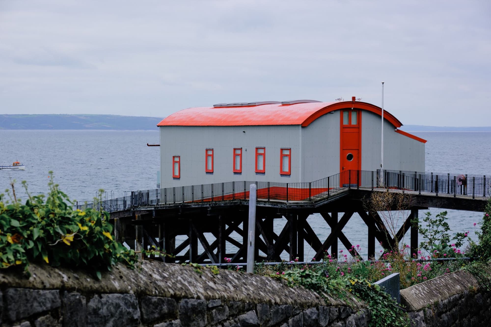 Lifeboat station on a pier in Tenby, Wales with scenic seascape backdrop.