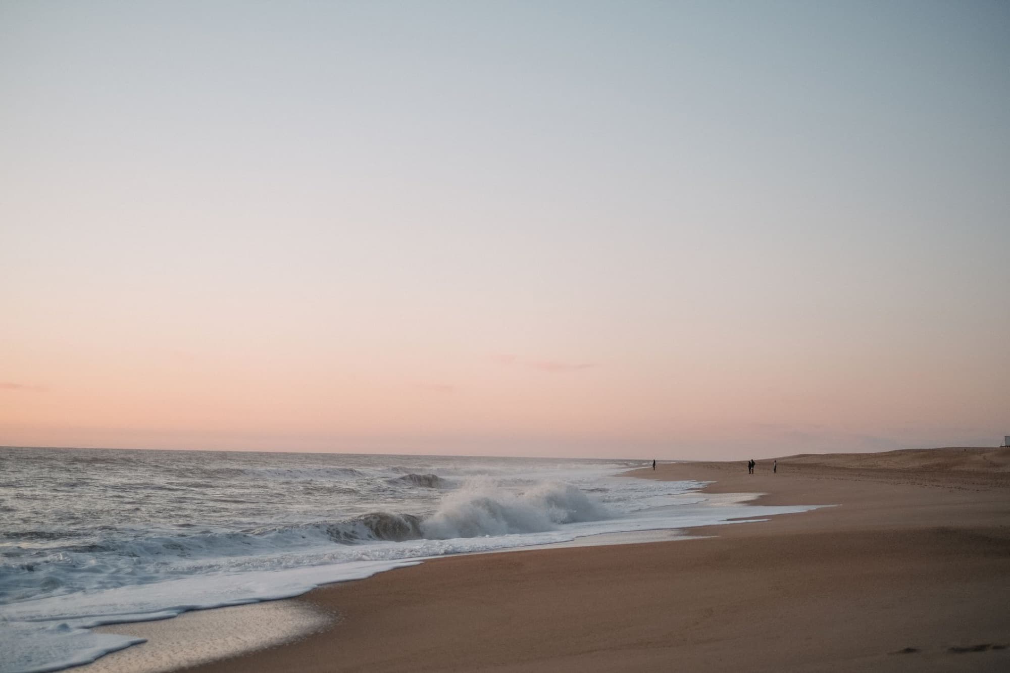 A peaceful beach view at sunset with gentle waves and a pastel sky, perfect for relaxation vibes.